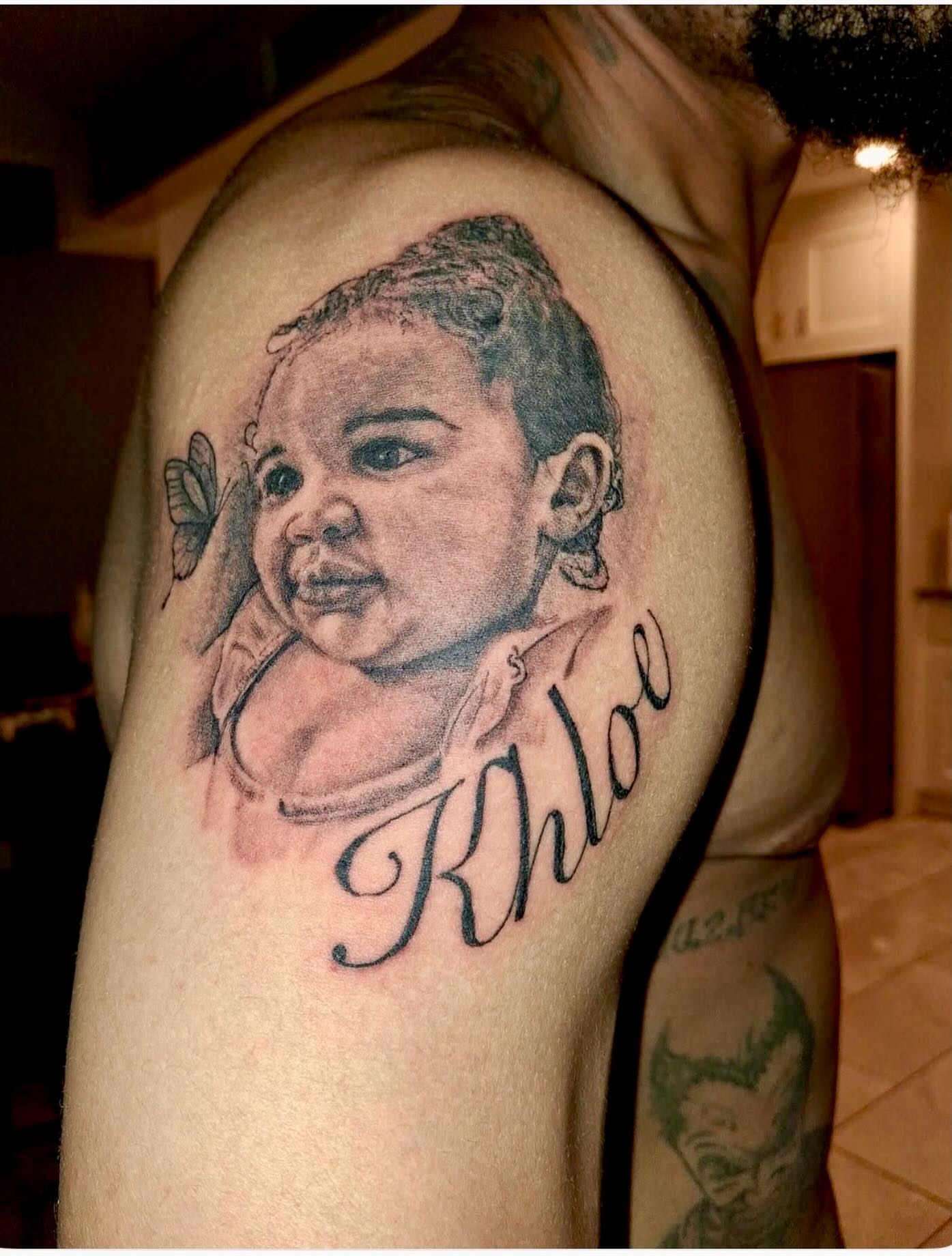 Baby portrait realism tattoo on the shoulder by Dre Ortiz