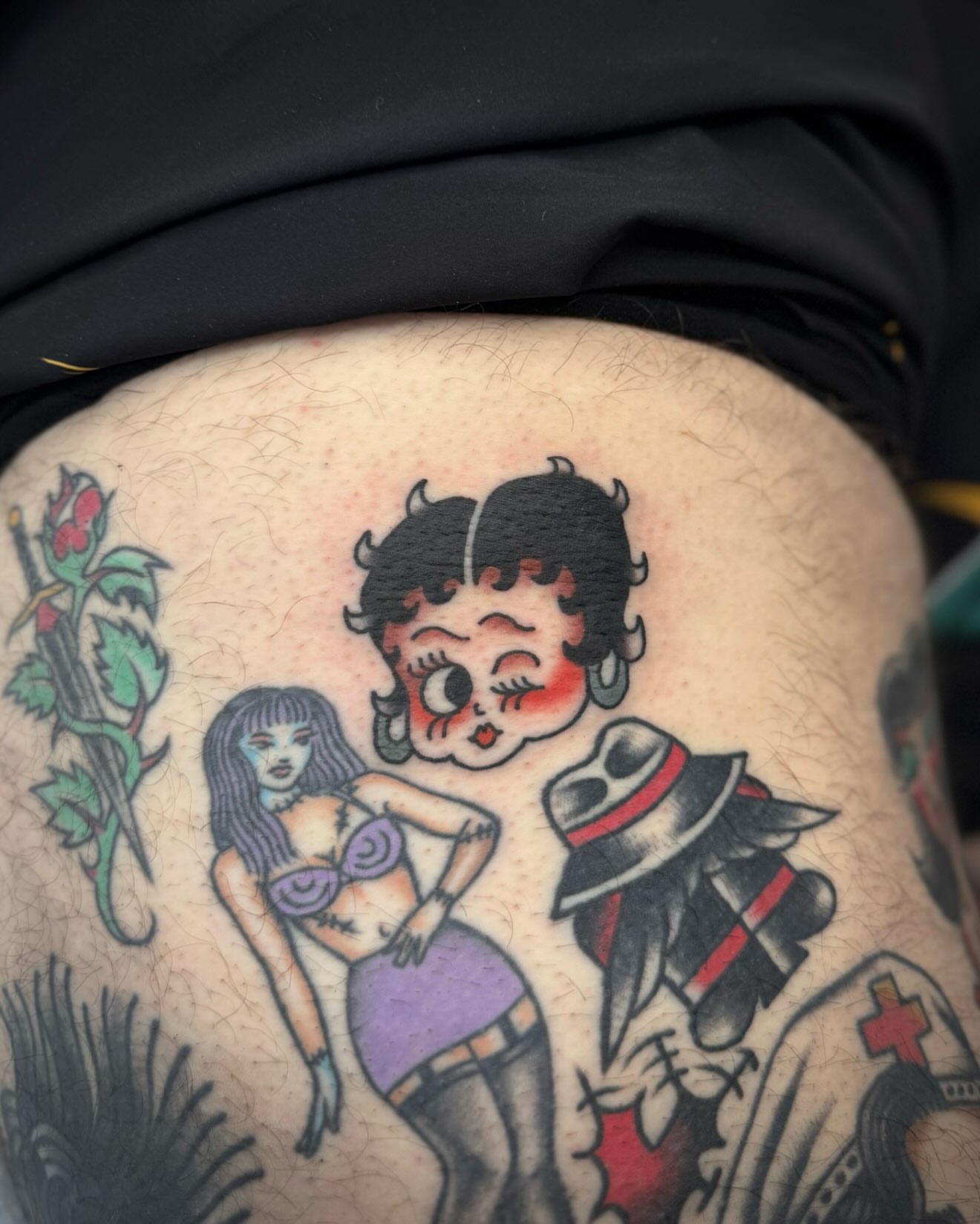 Betty Boop and woman American traditional tattoo on the thigh by kalli berry