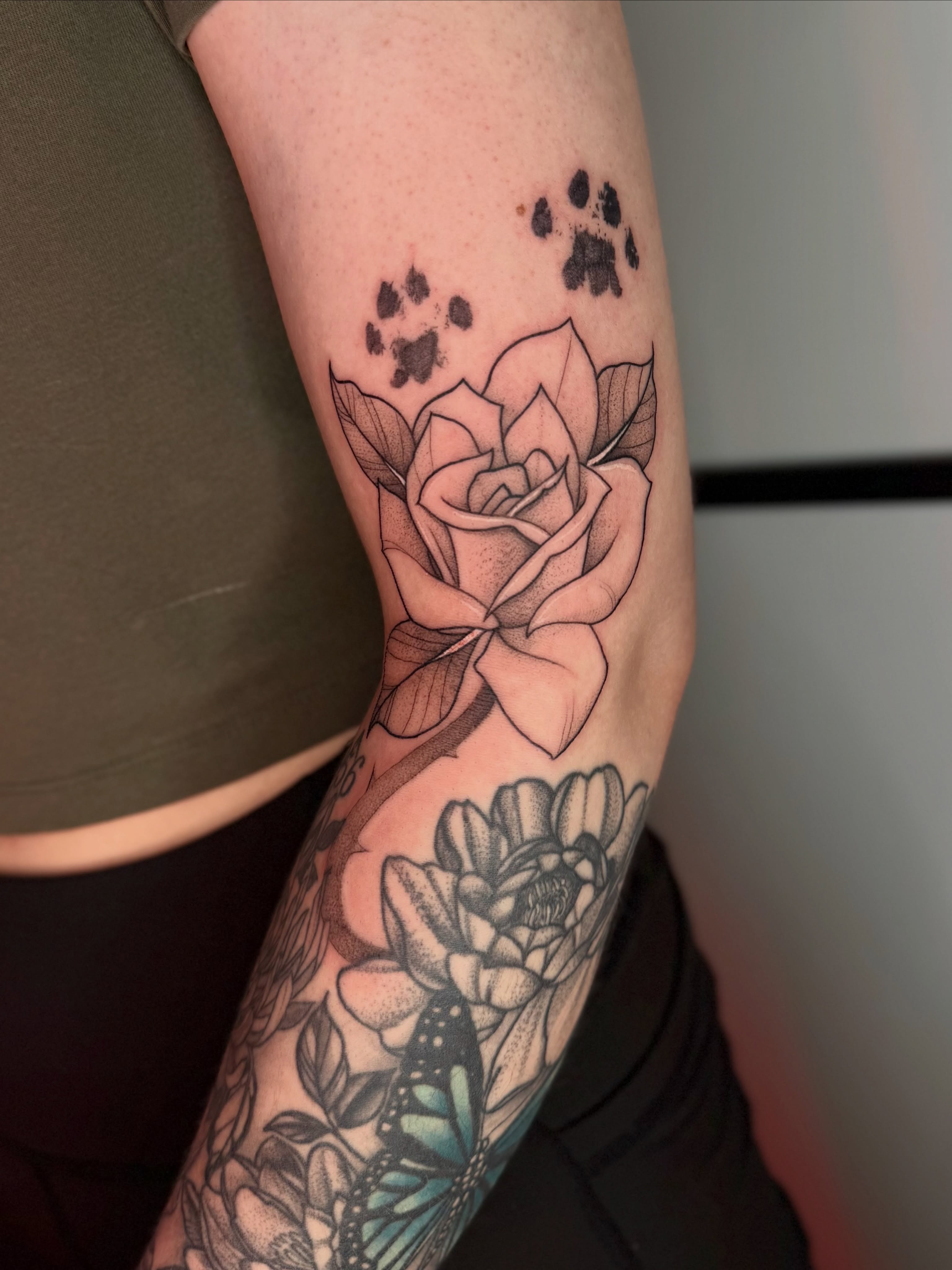 Rose and paw prints realism tattoo on the forearm by Dabbo🩸