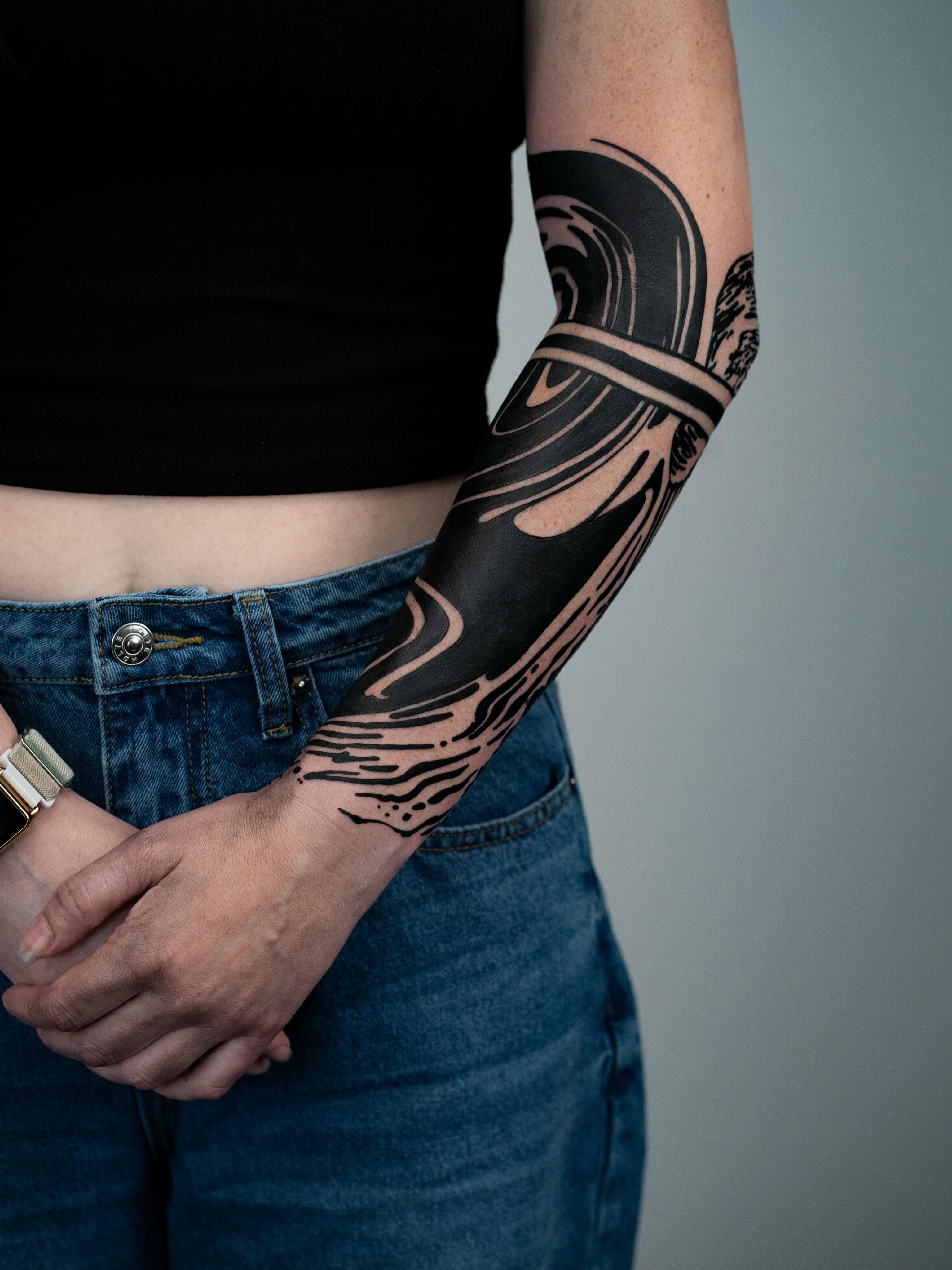 Abstract wave black and grey tattoo on the forearm by Josaline Green