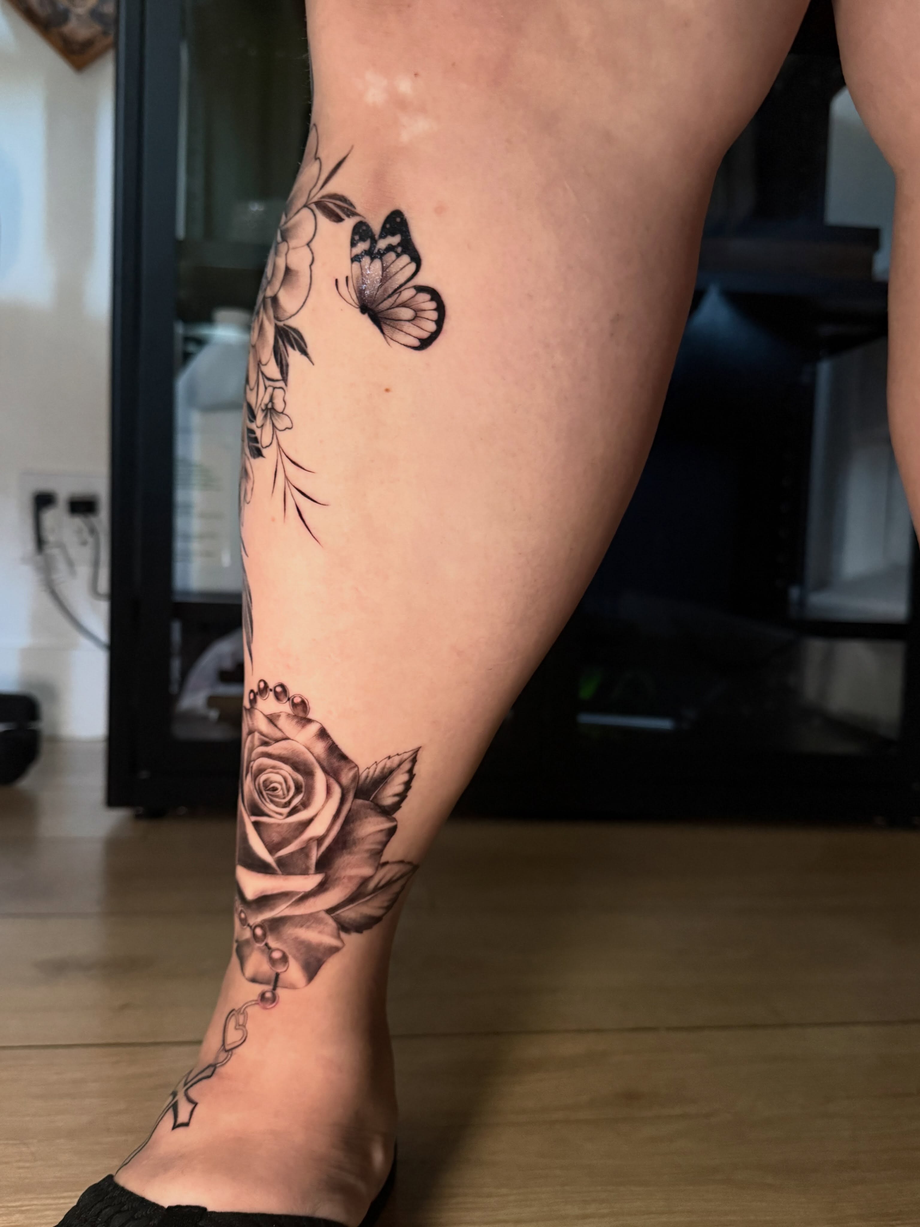 Rose and butterfly realism tattoo on the calf by Faith Lopez