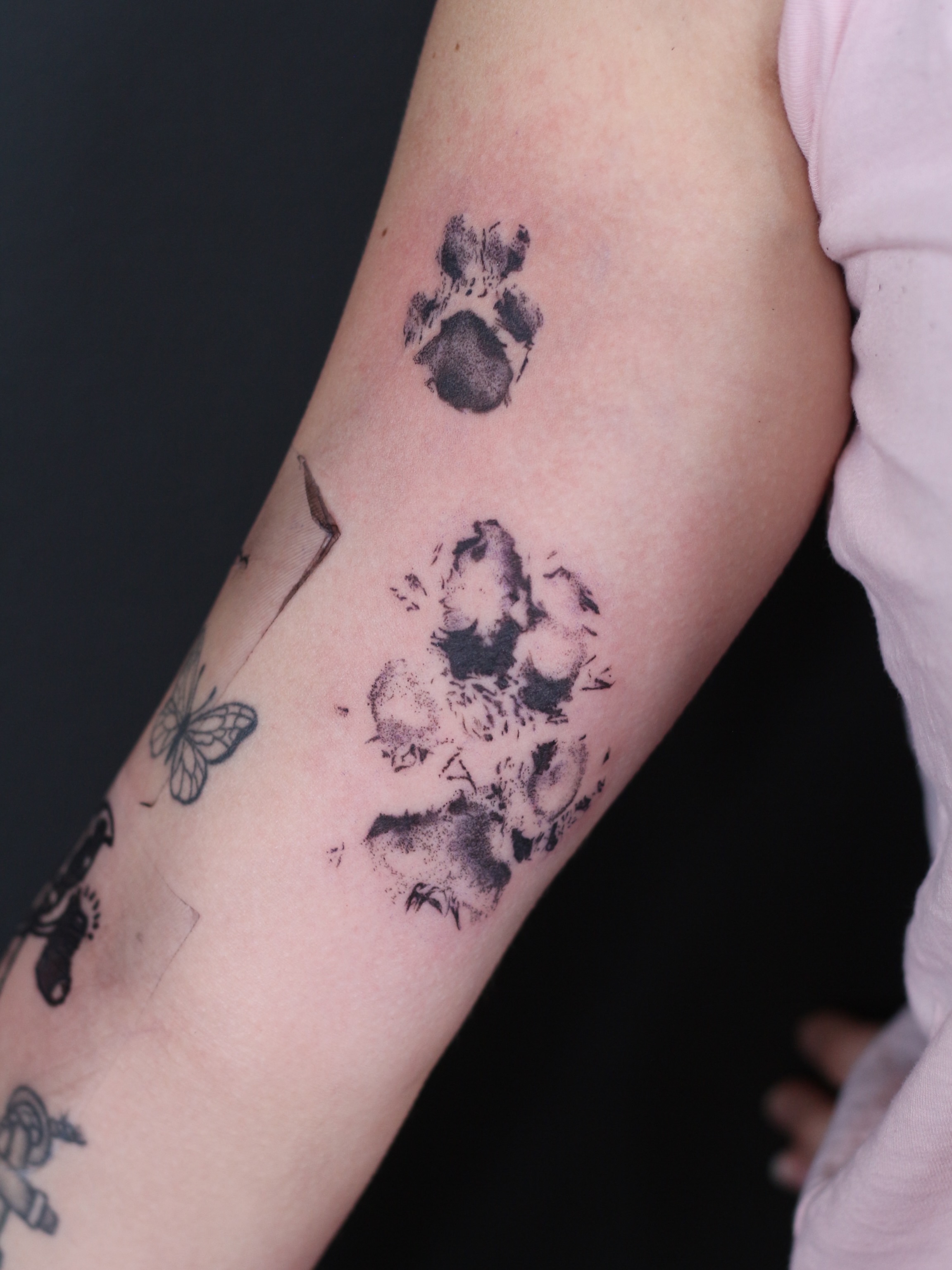 Paw prints dotwork tattoo on the forearm by Stephany Victorine