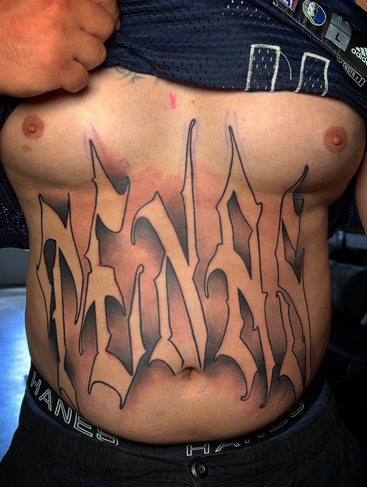 Graffiti-style lettering tattoo on the chest by Dallas tx tattoo artist ✝️