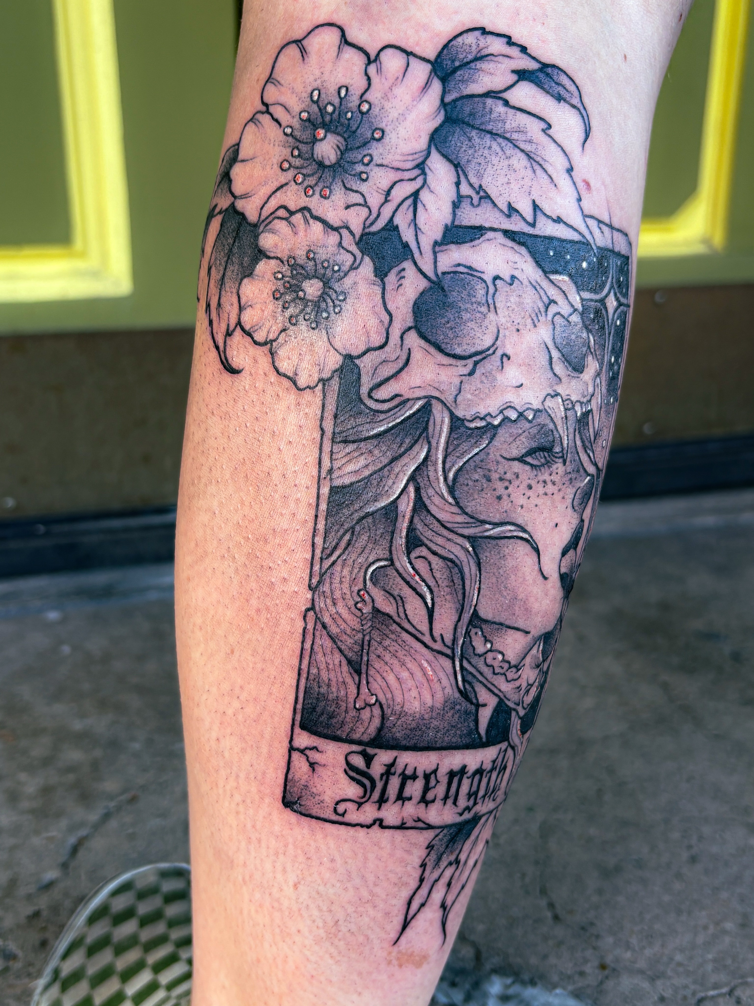 Skull and flowers realism tattoo on the forearm by Liz Cook