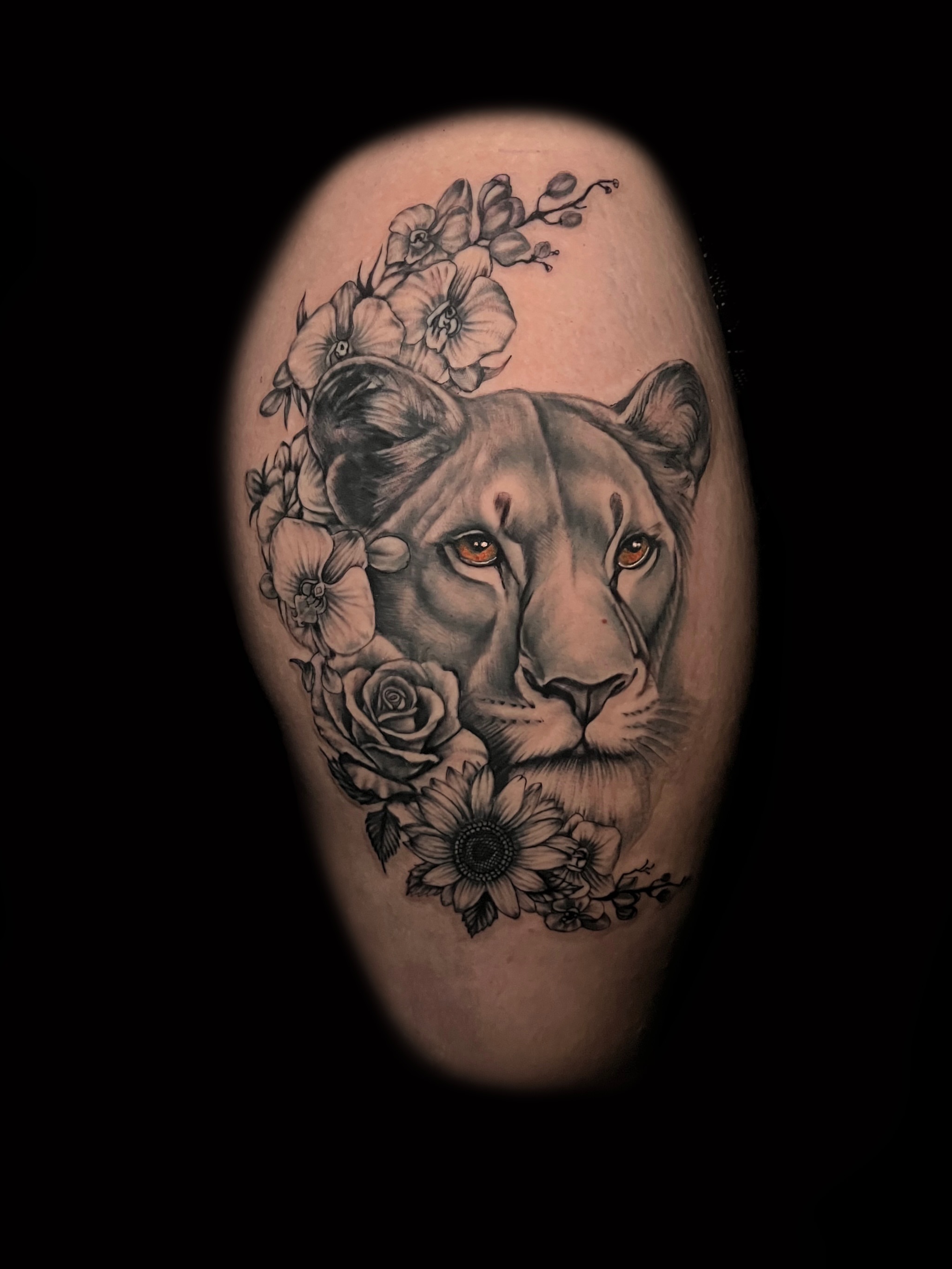 Lion with flowers realism tattoo on the thigh by Alex