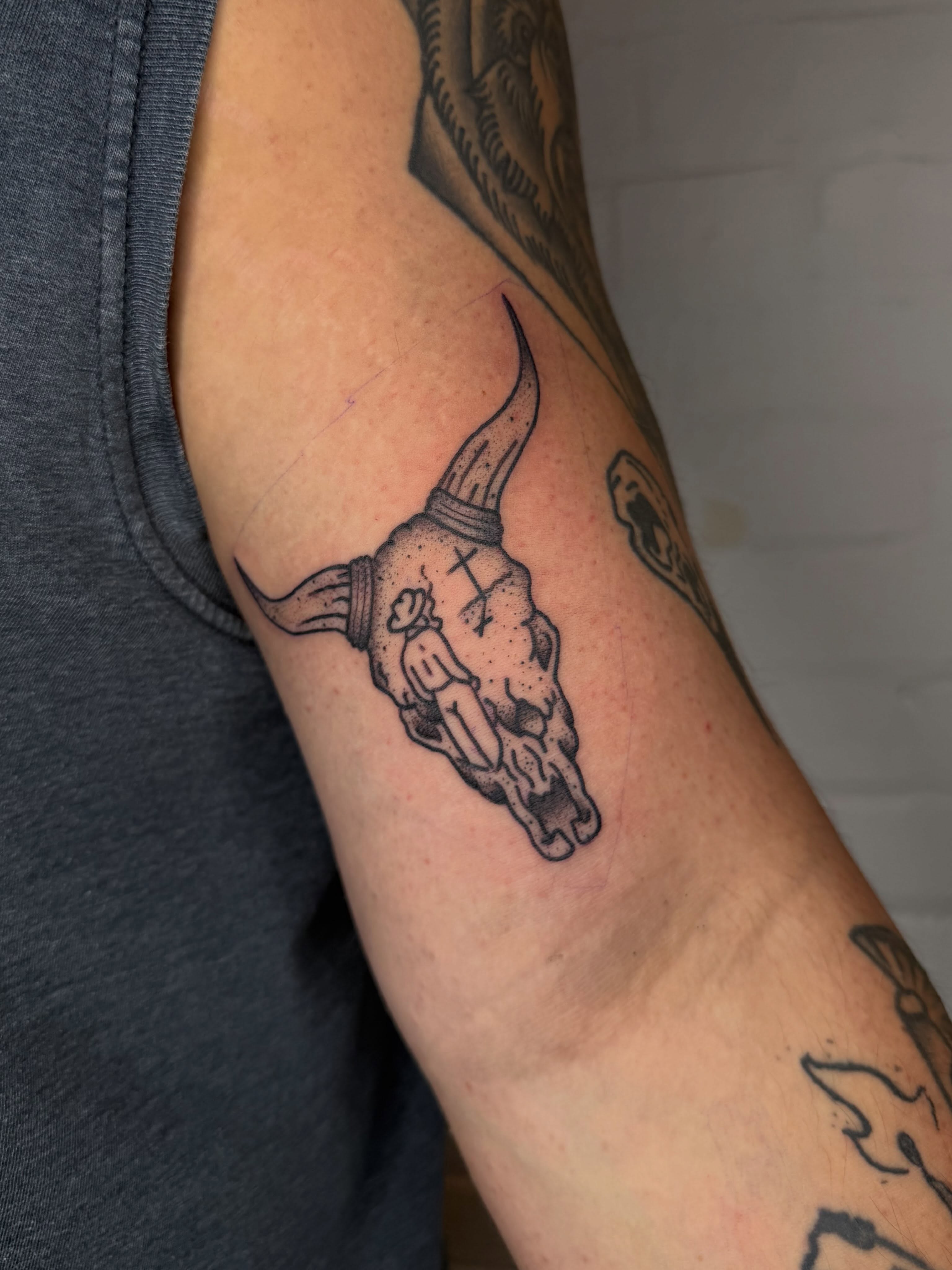 Bull skull black and grey tattoo on the forearm by Dennis Patterson