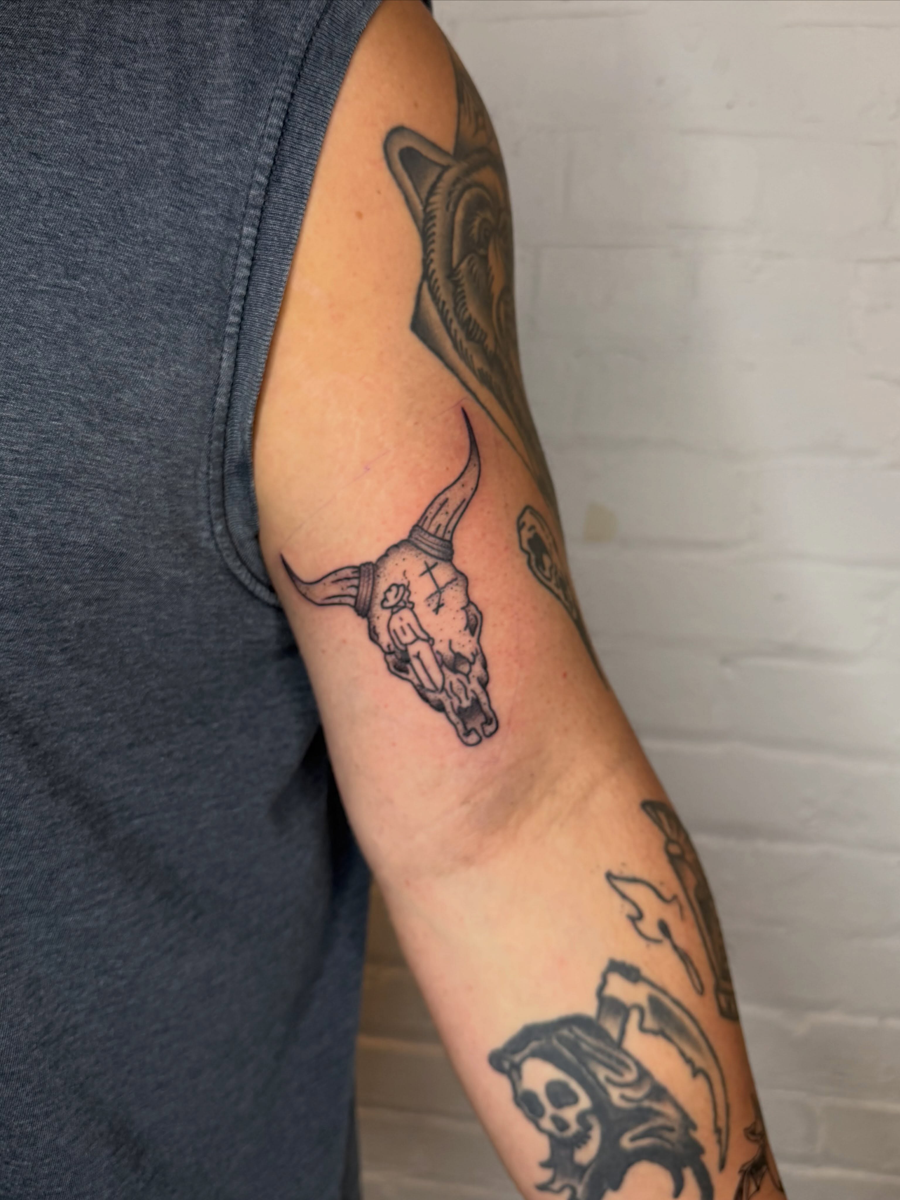 Bull skull black and grey tattoo on the forearm by Dennis Patterson