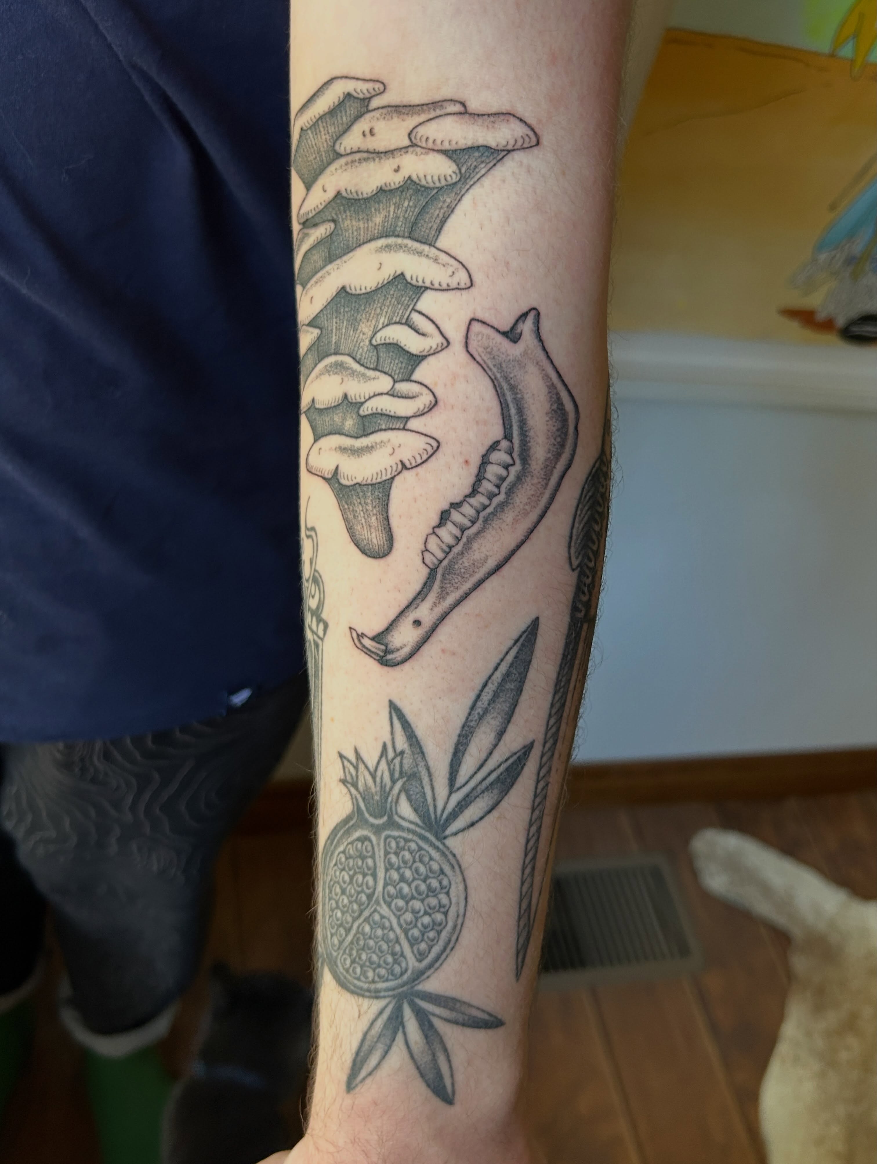 Snake and pomegranate black and grey tattoo on the forearm by Janelle McCarthy