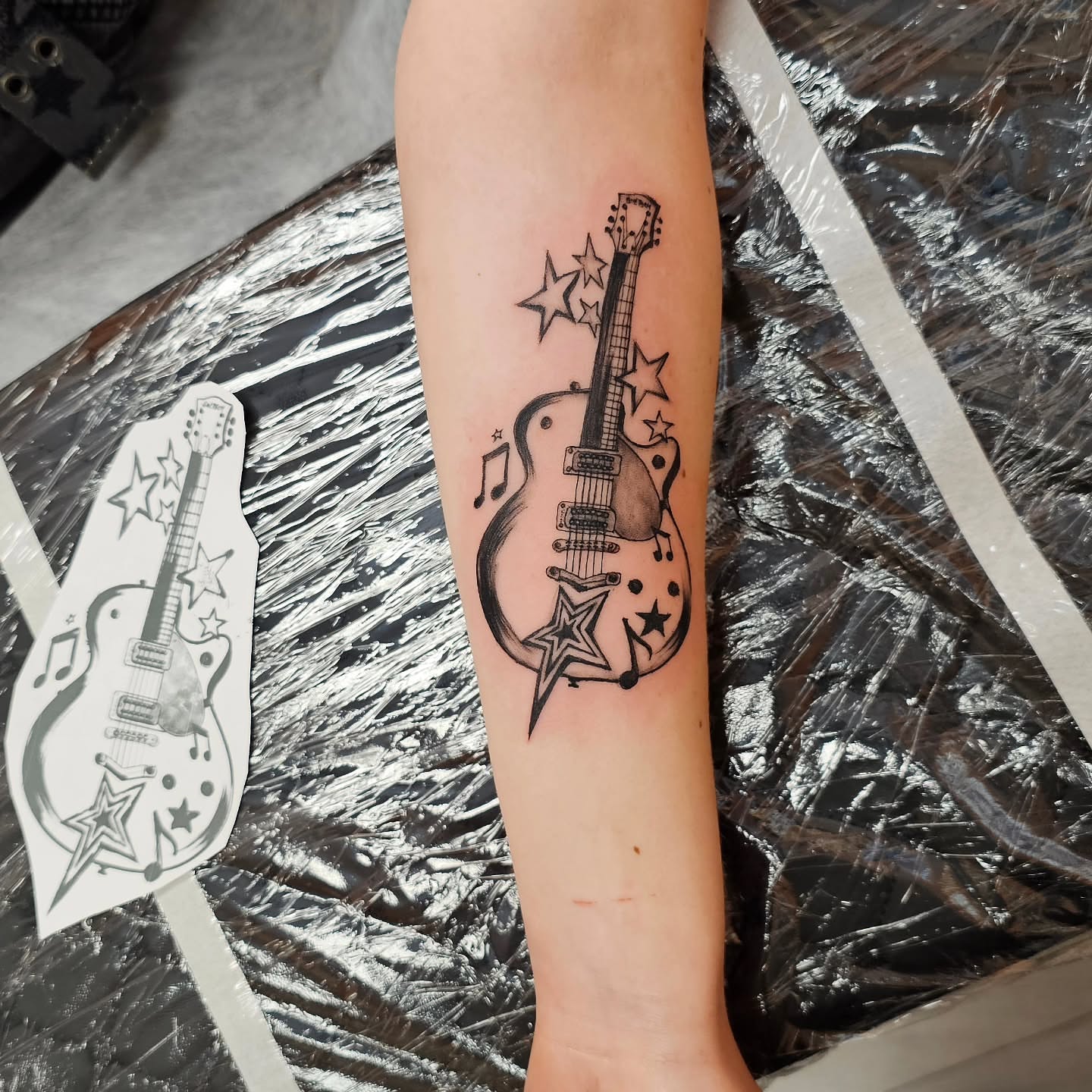 Electric guitar black and grey tattoo on the forearm by Lili Gu