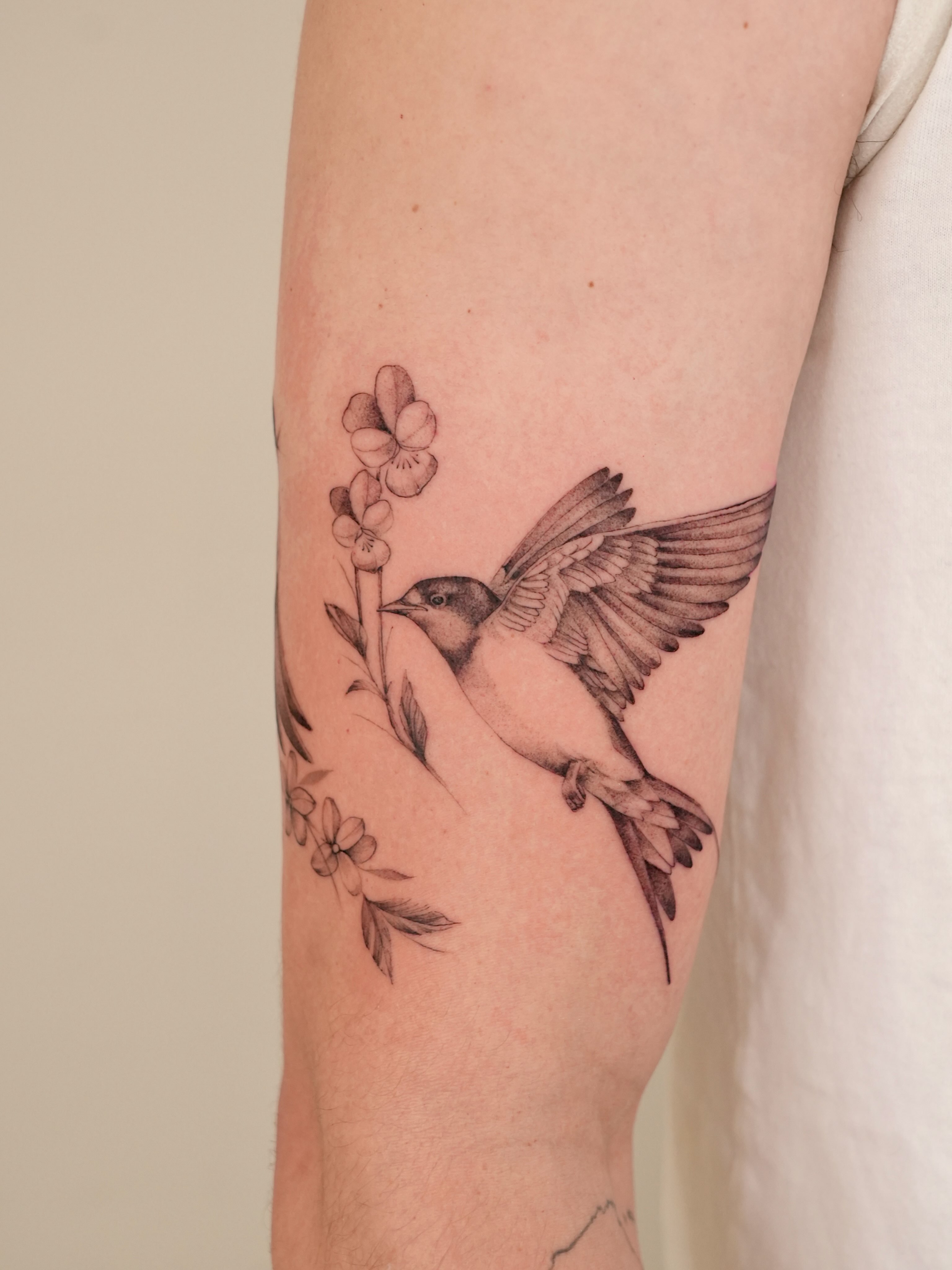 Bird and flowers black and grey tattoo on the forearm by Marianna D D King