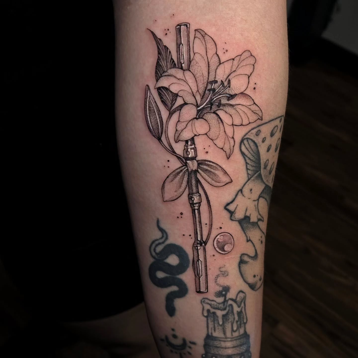 Flower bouquet with gun dotwork tattoo on the forearm by Jesseca Chinchilla