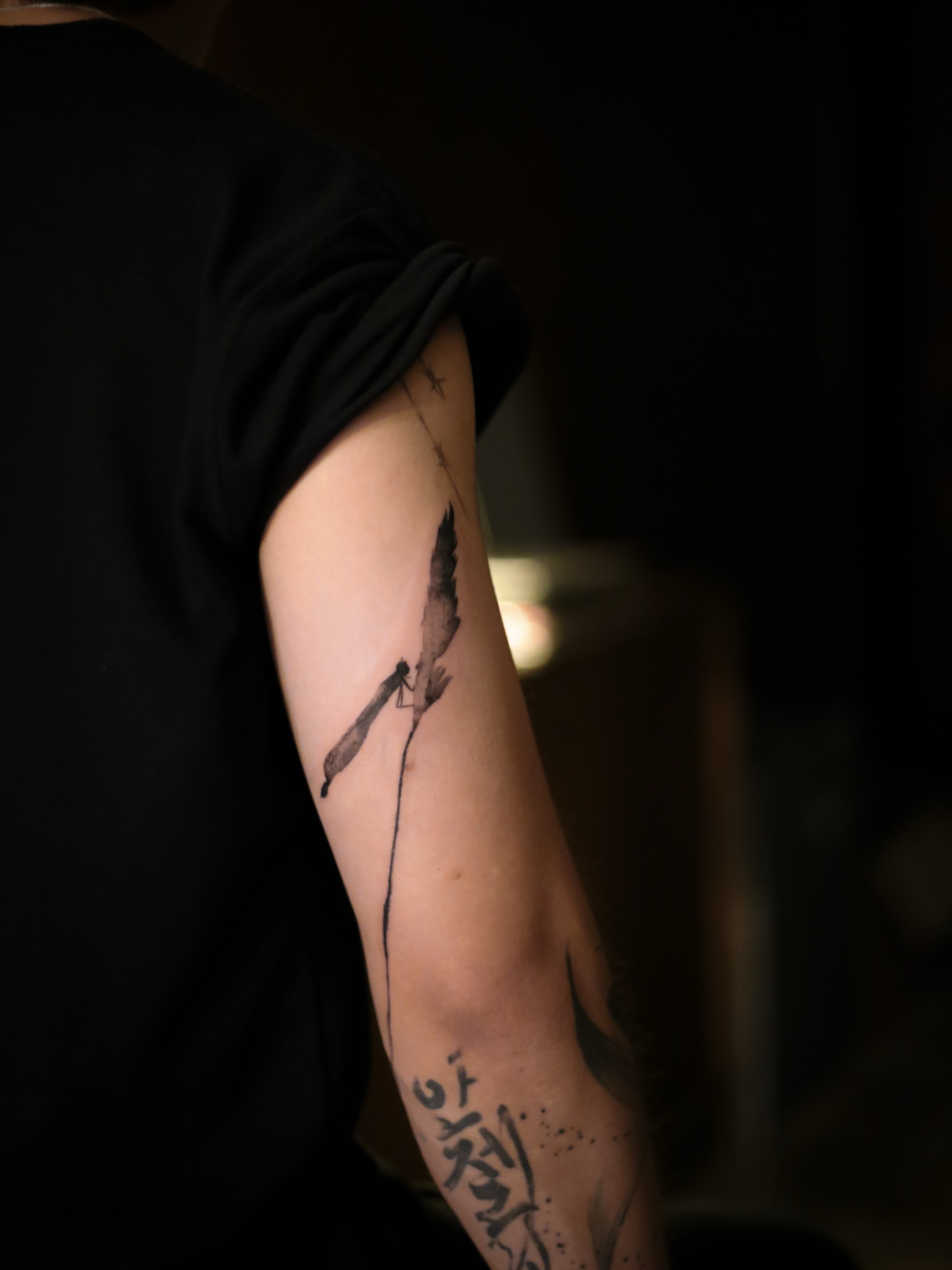 Feather black and grey tattoo on the forearm by Blight