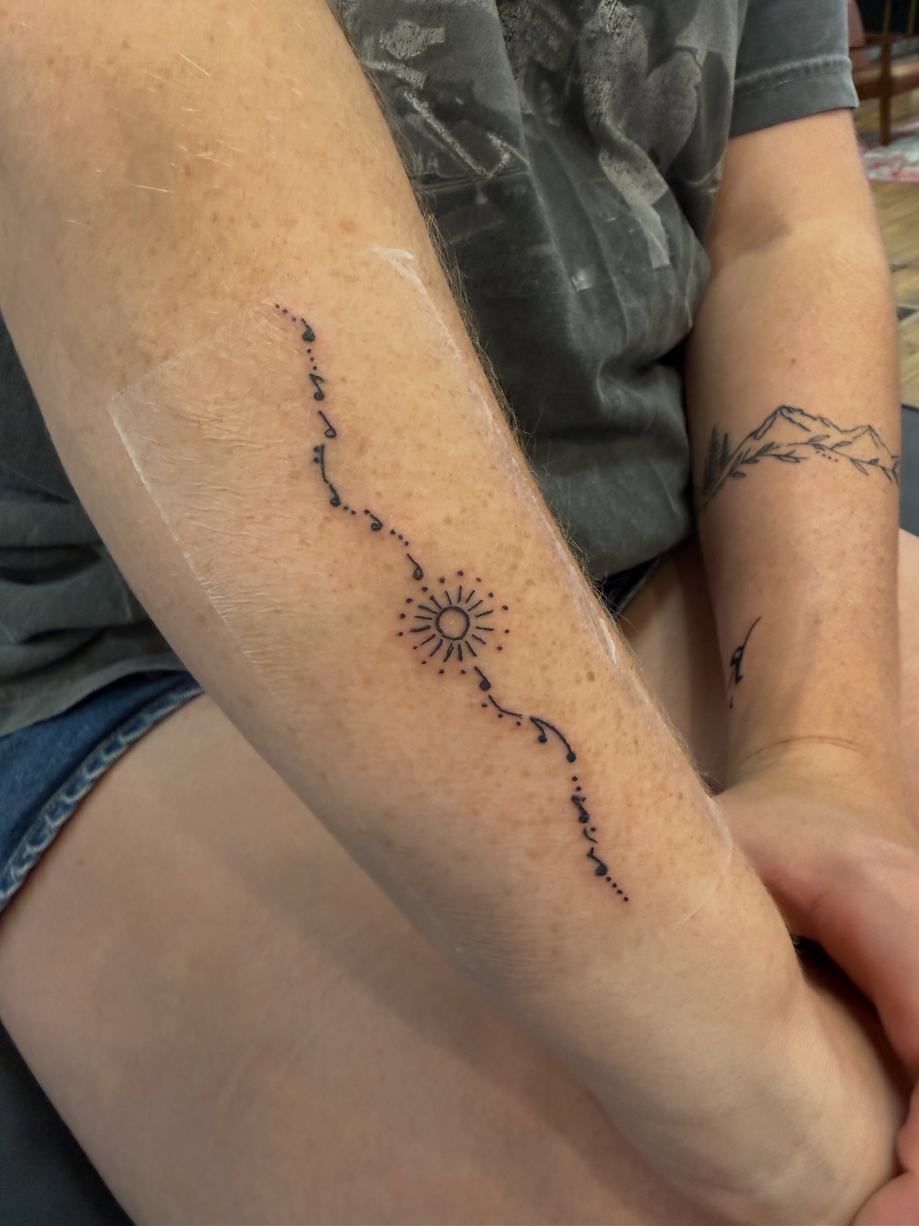 Sun and rays dotwork tattoo on the forearm by Whimsy Ink