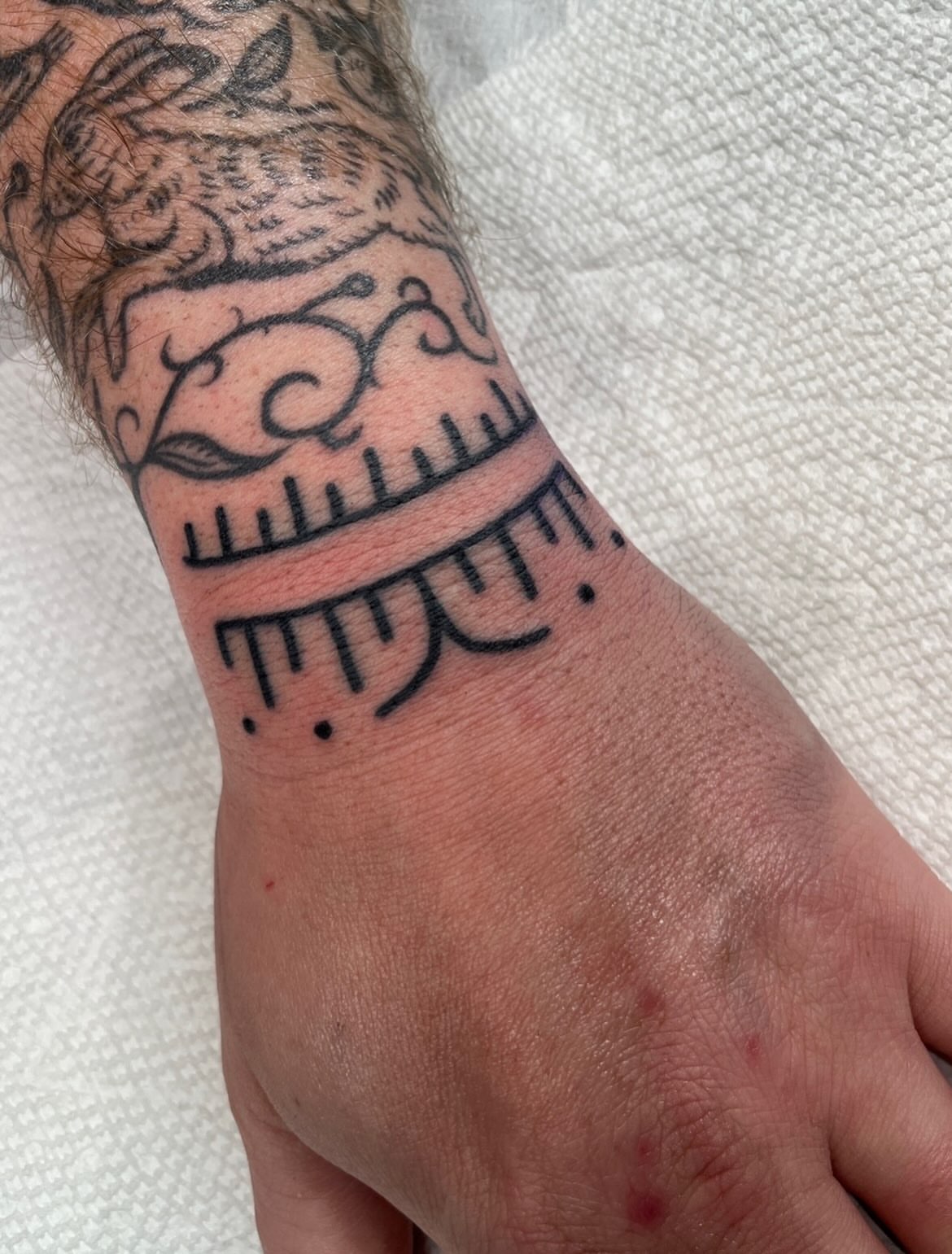 Ruler and floral black and grey tattoo on the forearm by Charlie Ostrom, Durham, North Carolina
