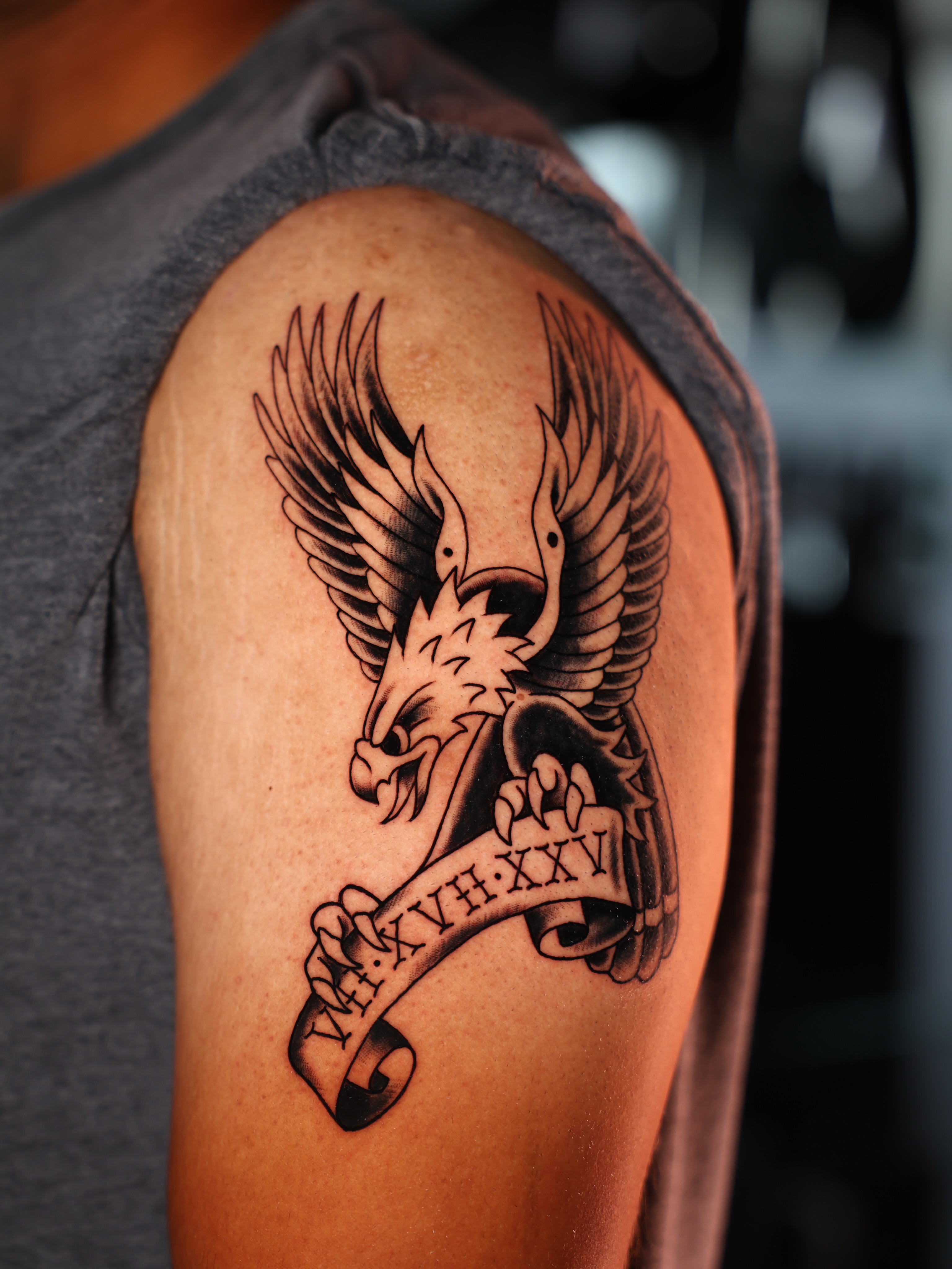 Eagle with banner black and grey tattoo on the shoulder by Josh Brownell