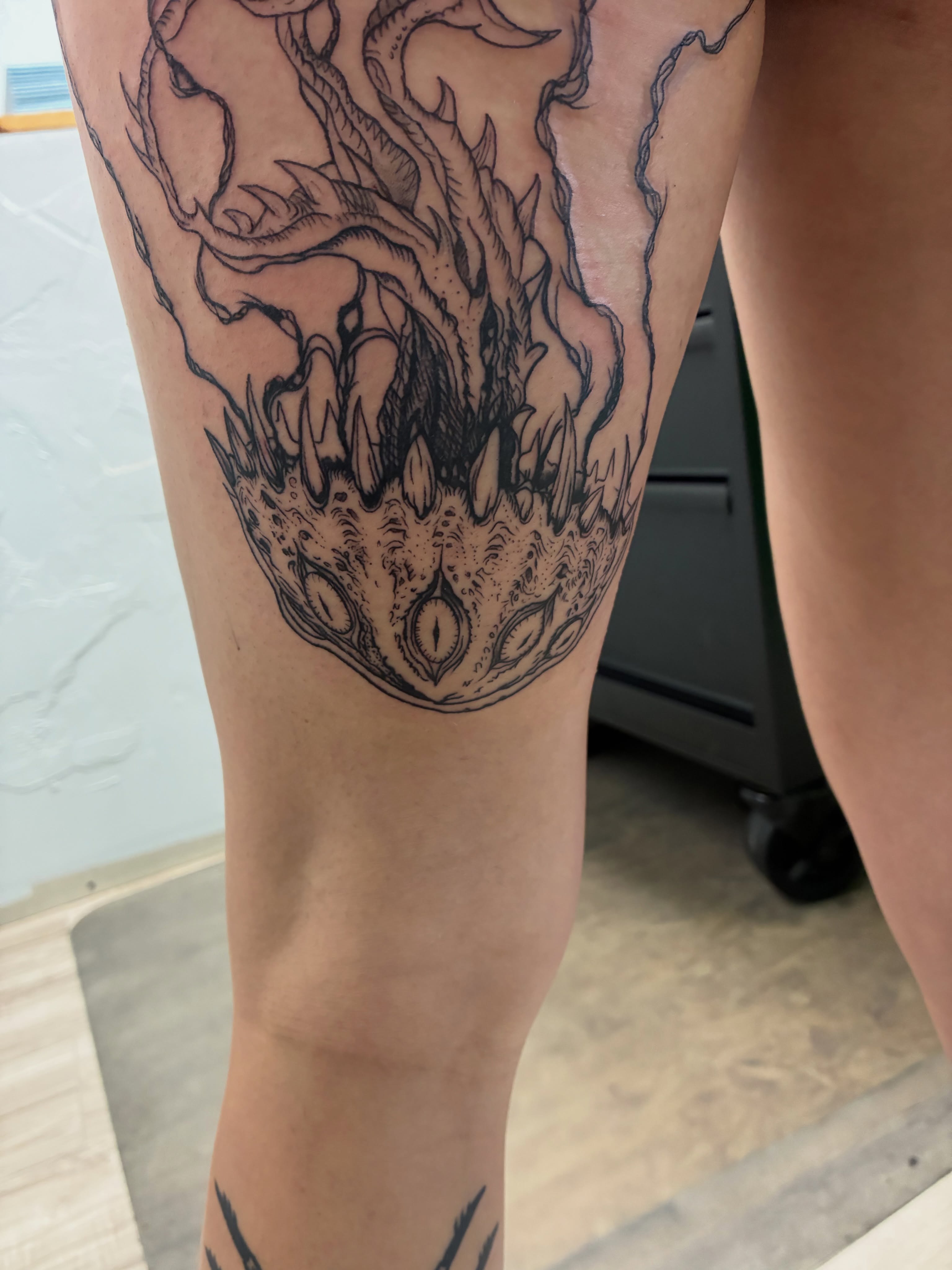 Tree with flames black and grey tattoo on the thigh by James Ostler