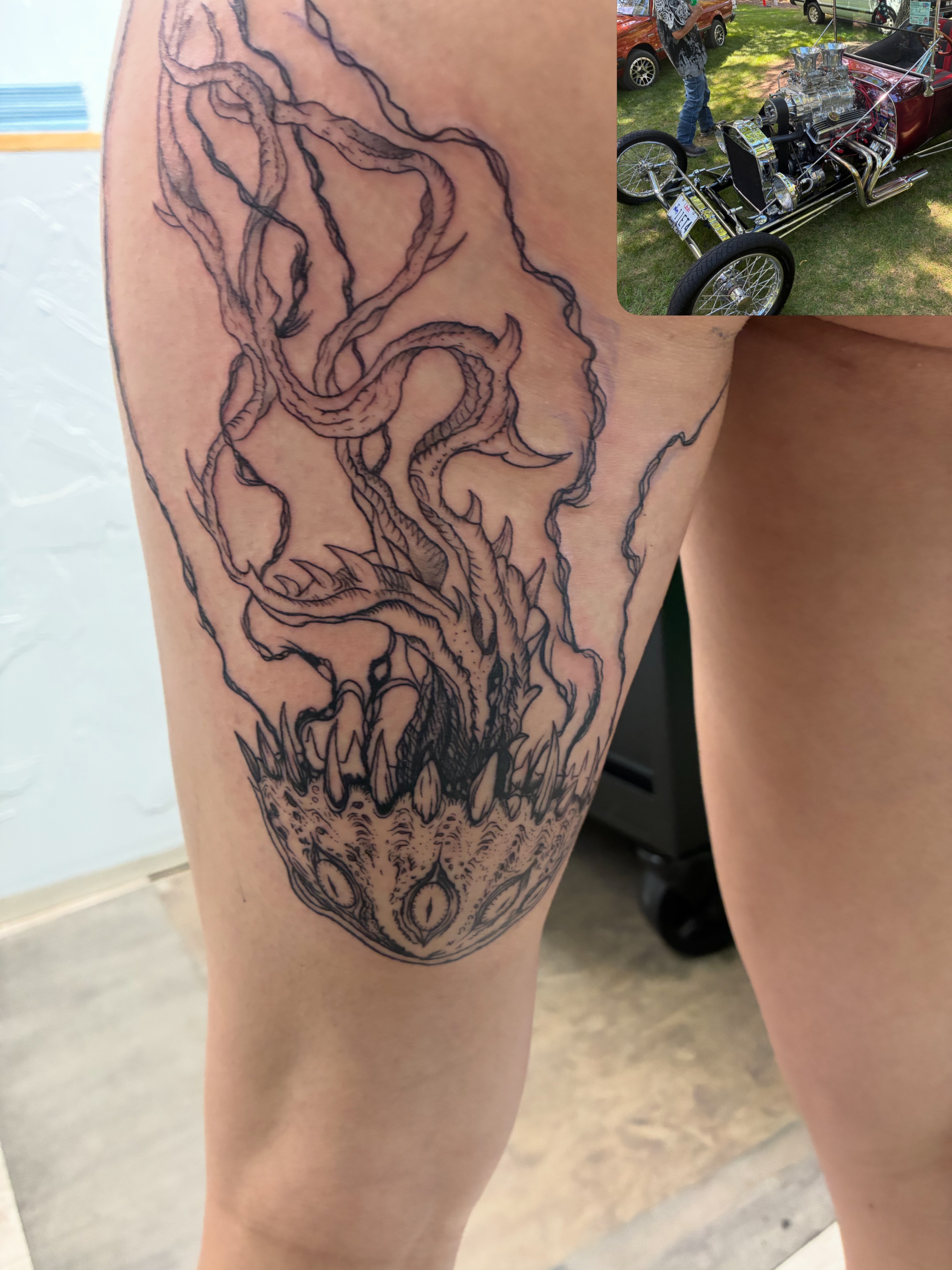 Dragon black and grey tattoo on the thigh by James Ostler