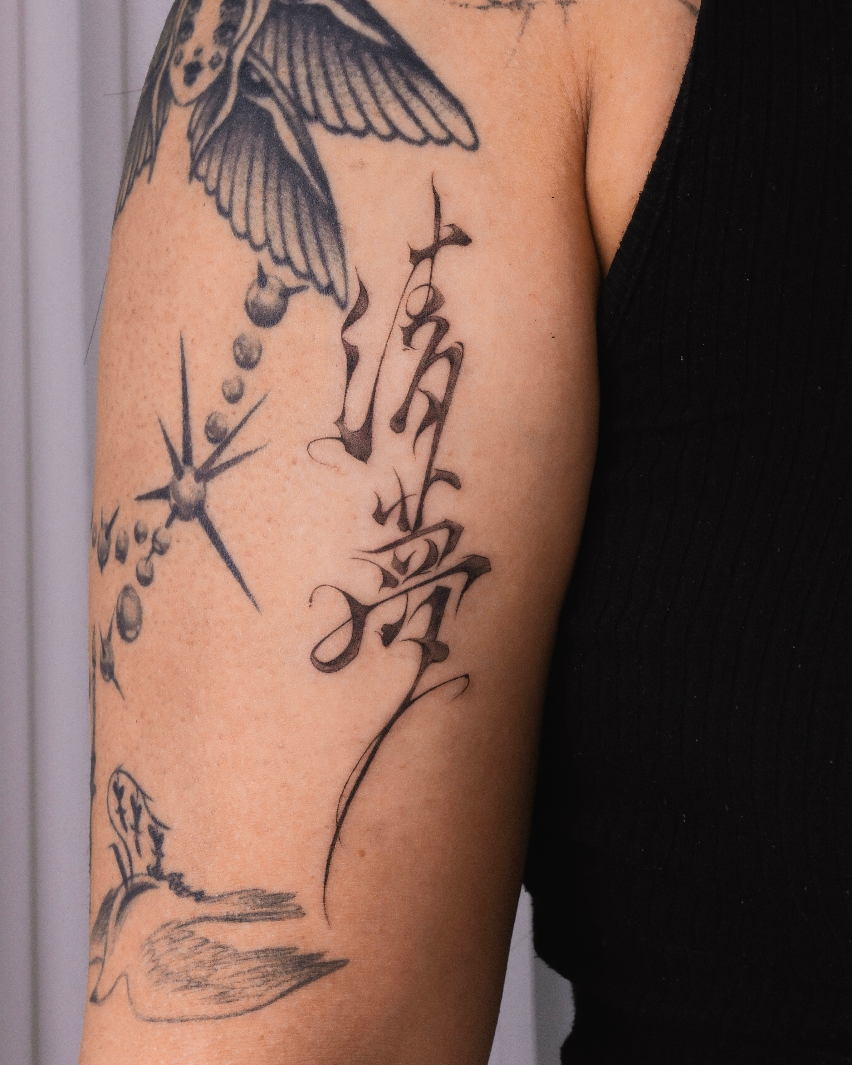 Bird, hand, starburst, bubbles black and grey tattoo on the forearm by Max