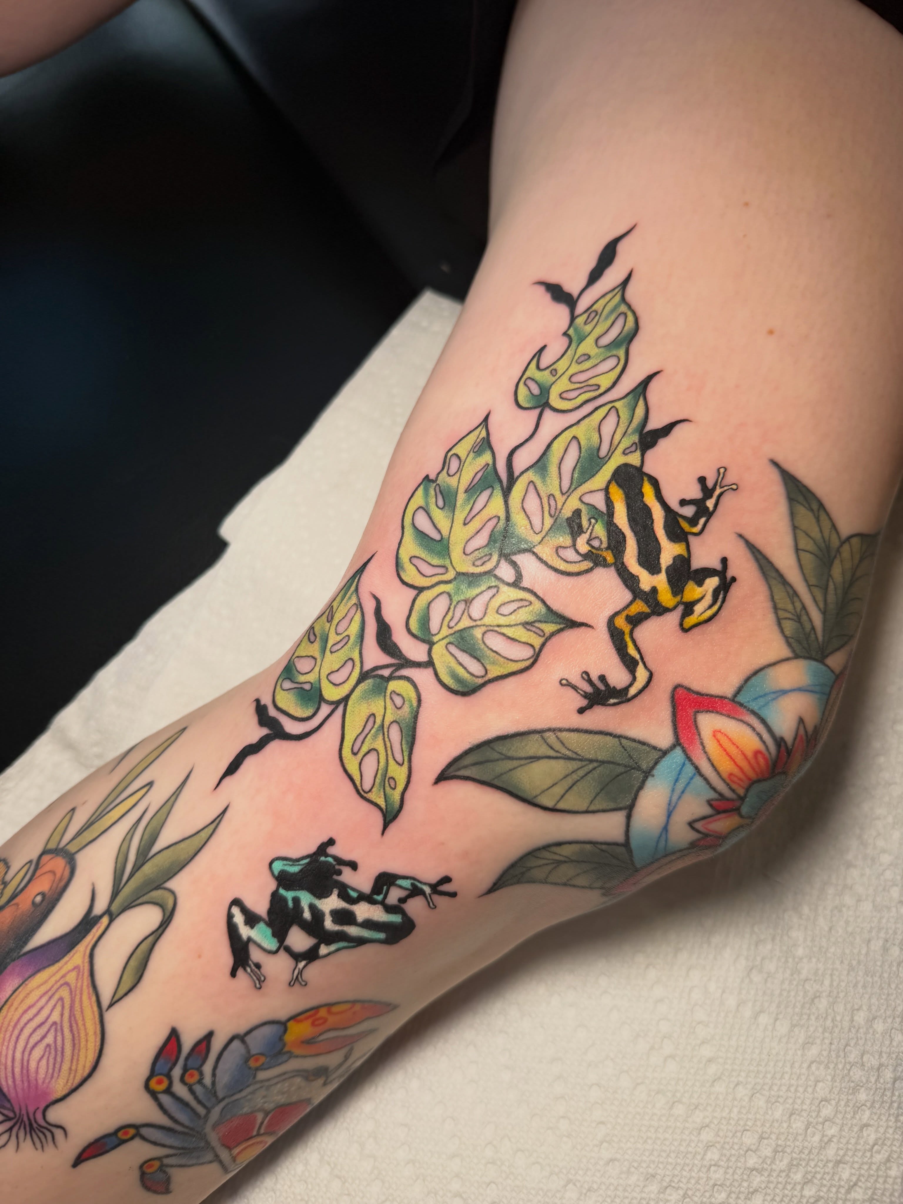 Jungle frogs and foliage American traditional tattoo on the forearm by Lyndze Masters