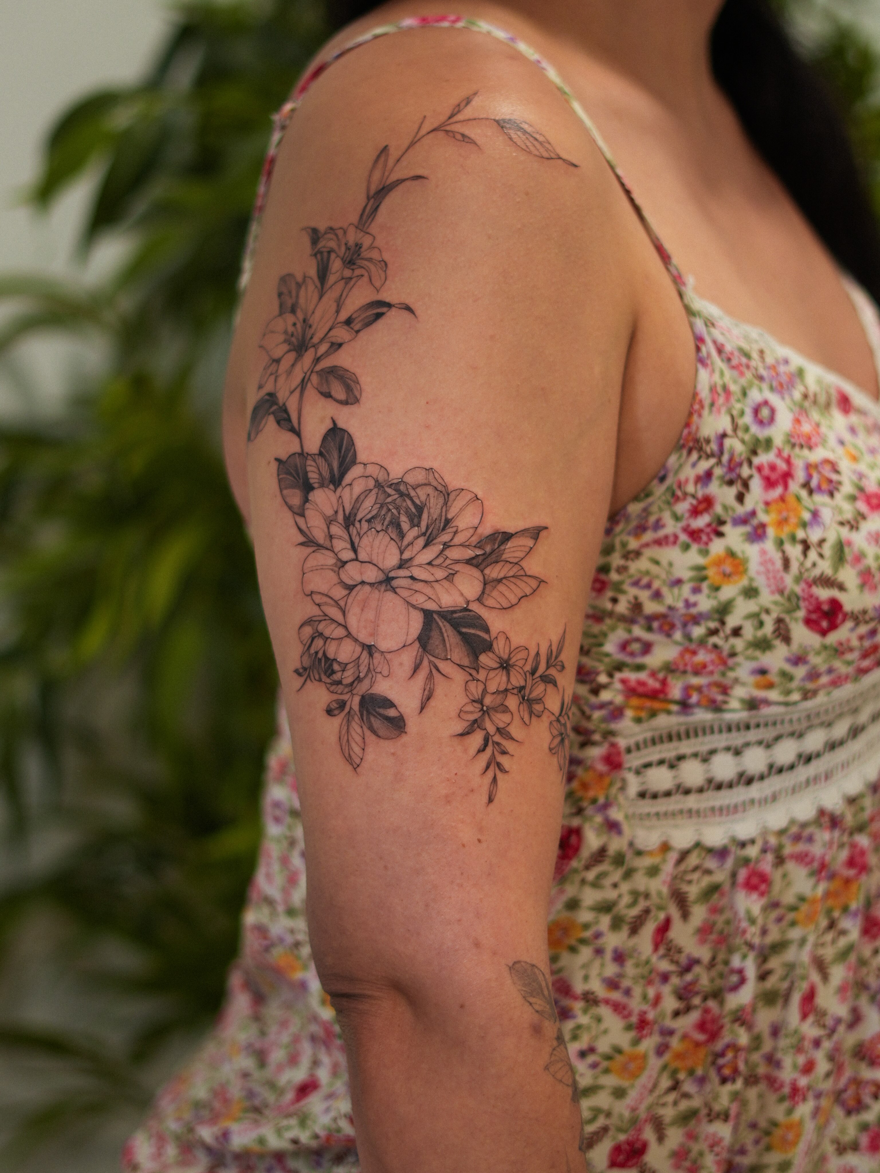 Floral bouquet black and grey tattoo on the upper arm by Adriano Bassalo