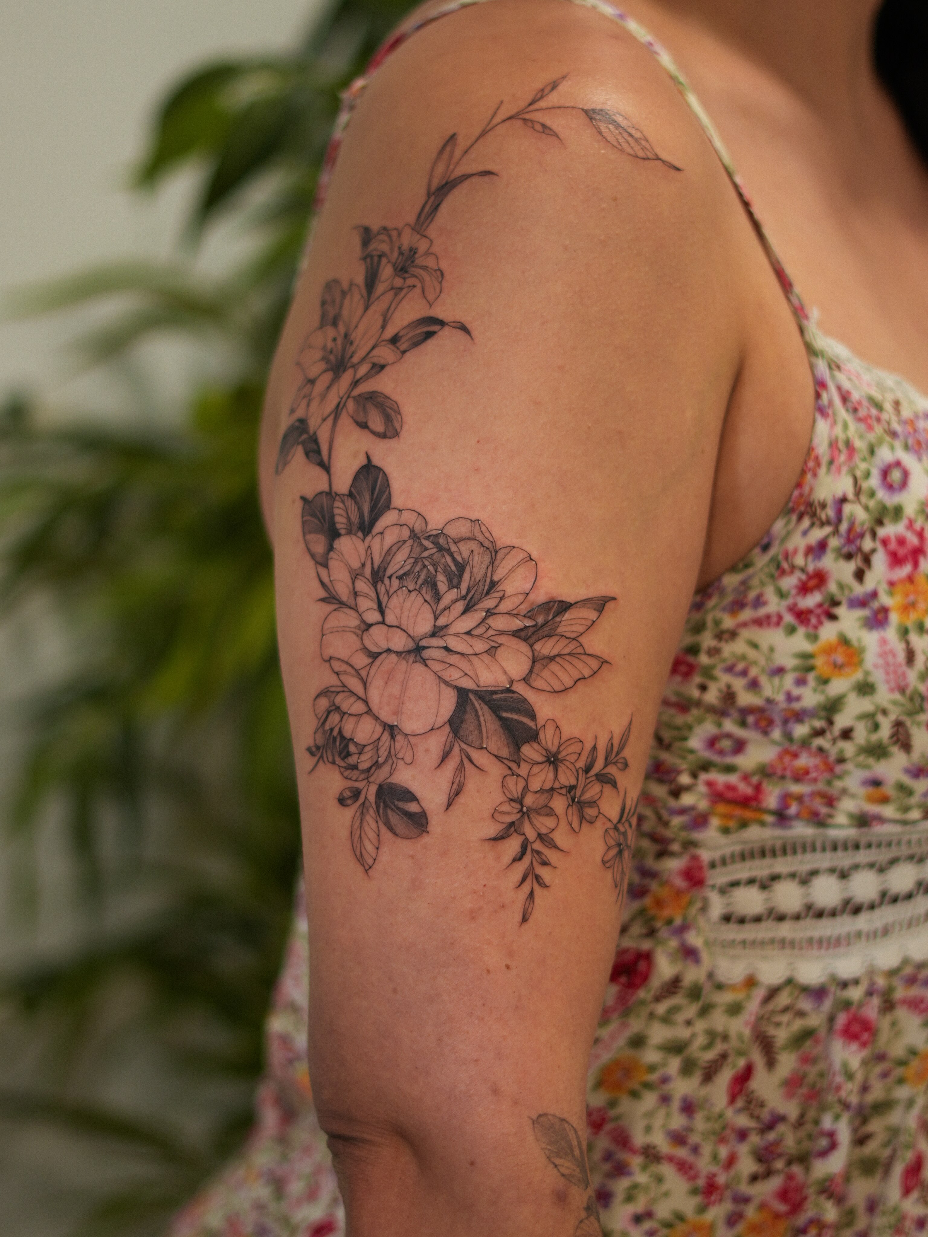 Floral bouquet black and grey tattoo on the upper arm by Adriano Bassalo