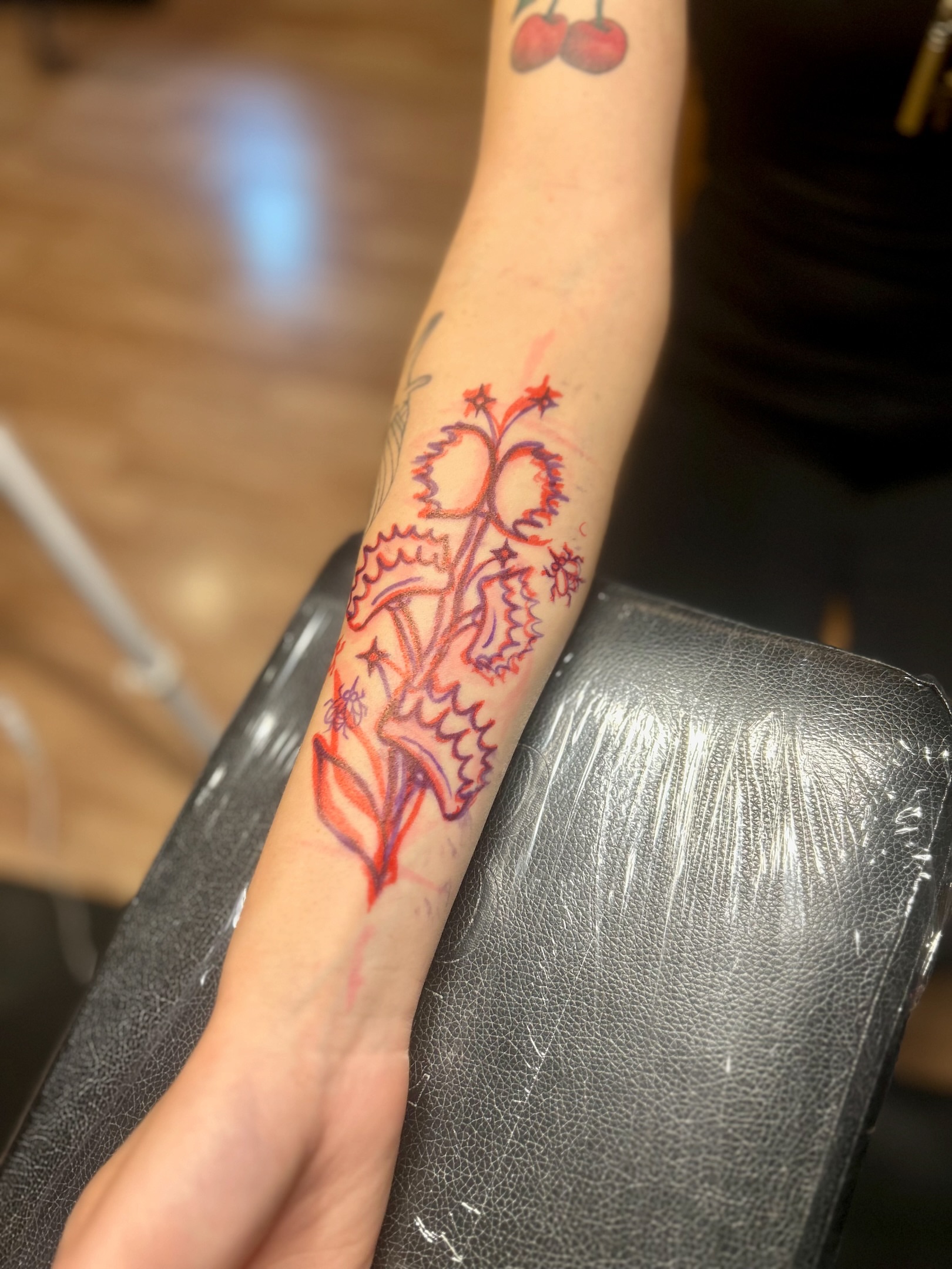 Floral design watercolor tattoo on the forearm by Tori Magill
