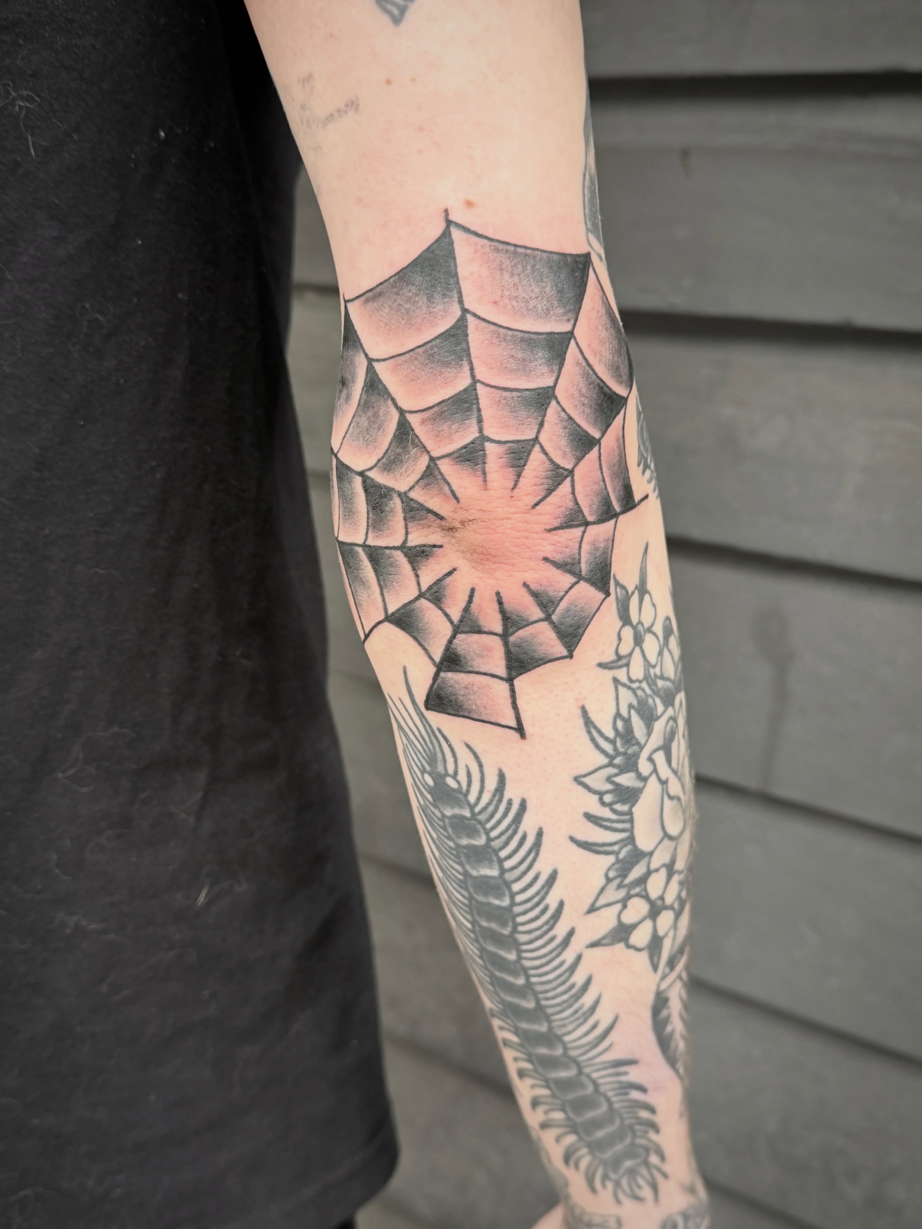 Spider web geometric tattoo on the forearm by Chris Blanchard
