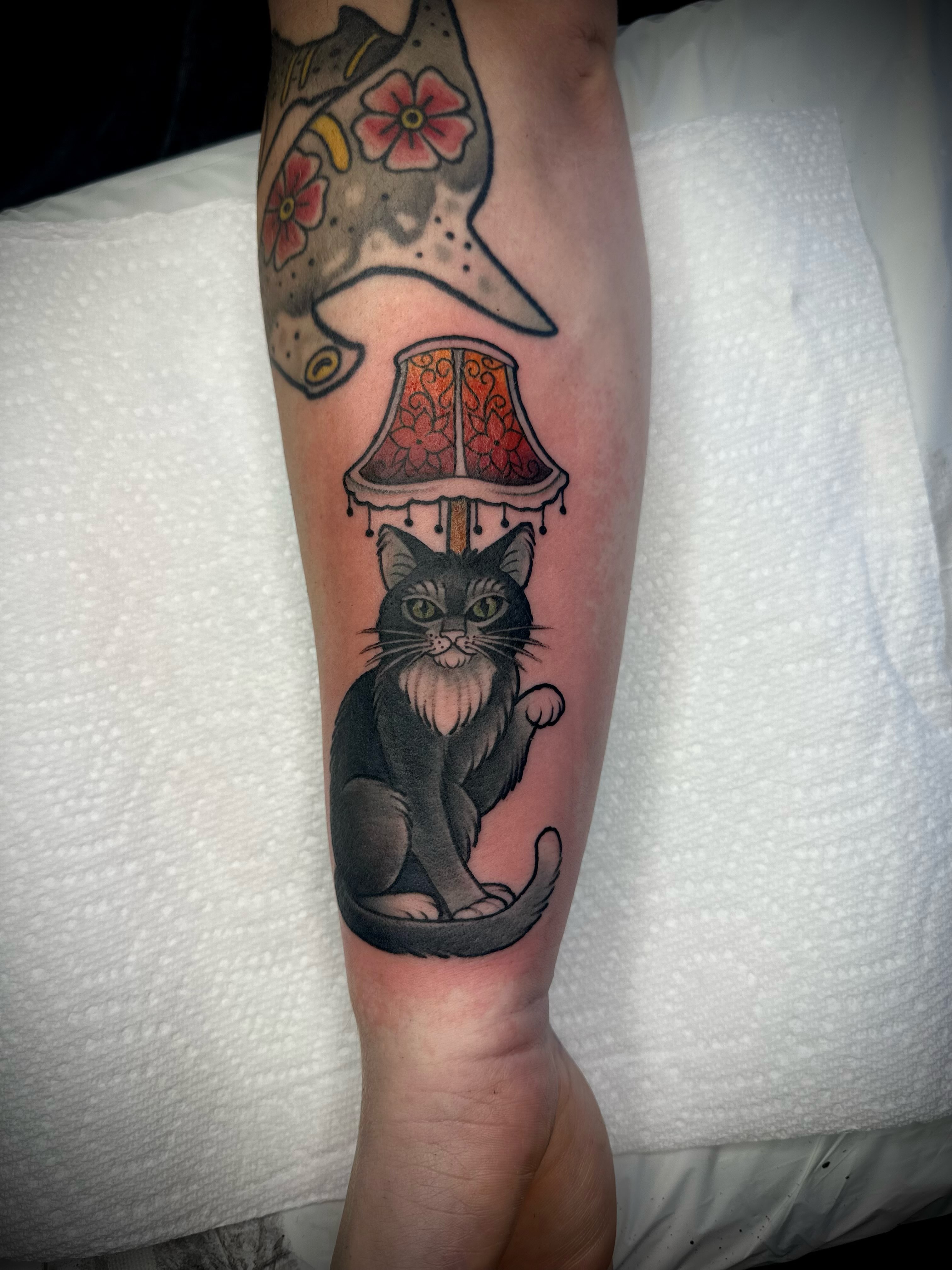 Cat and lampshade American traditional tattoo on the forearm by Madison Orchard Tattoos