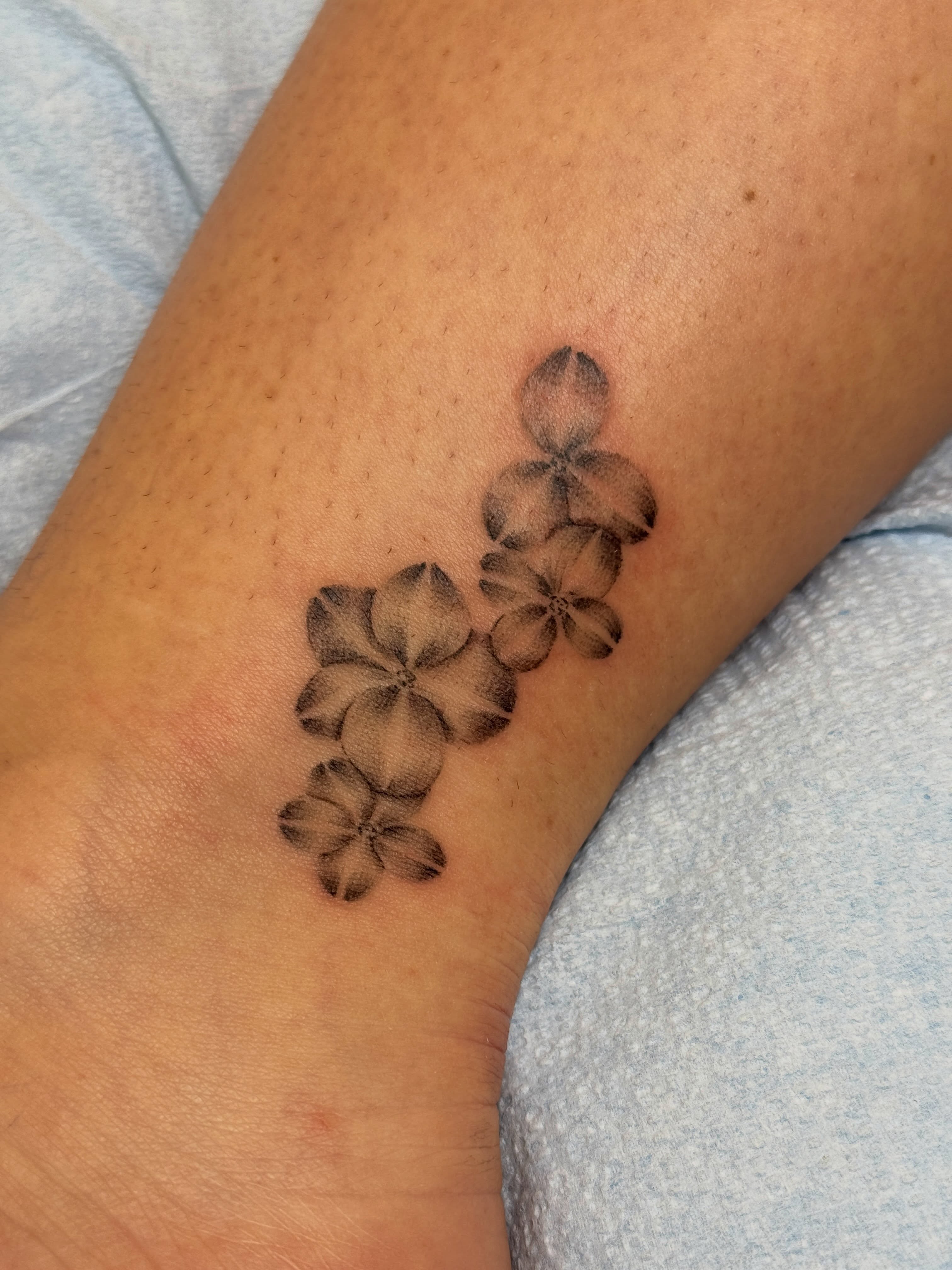Flower arrangement black and grey tattoo on the forearm by Monica Reynolds