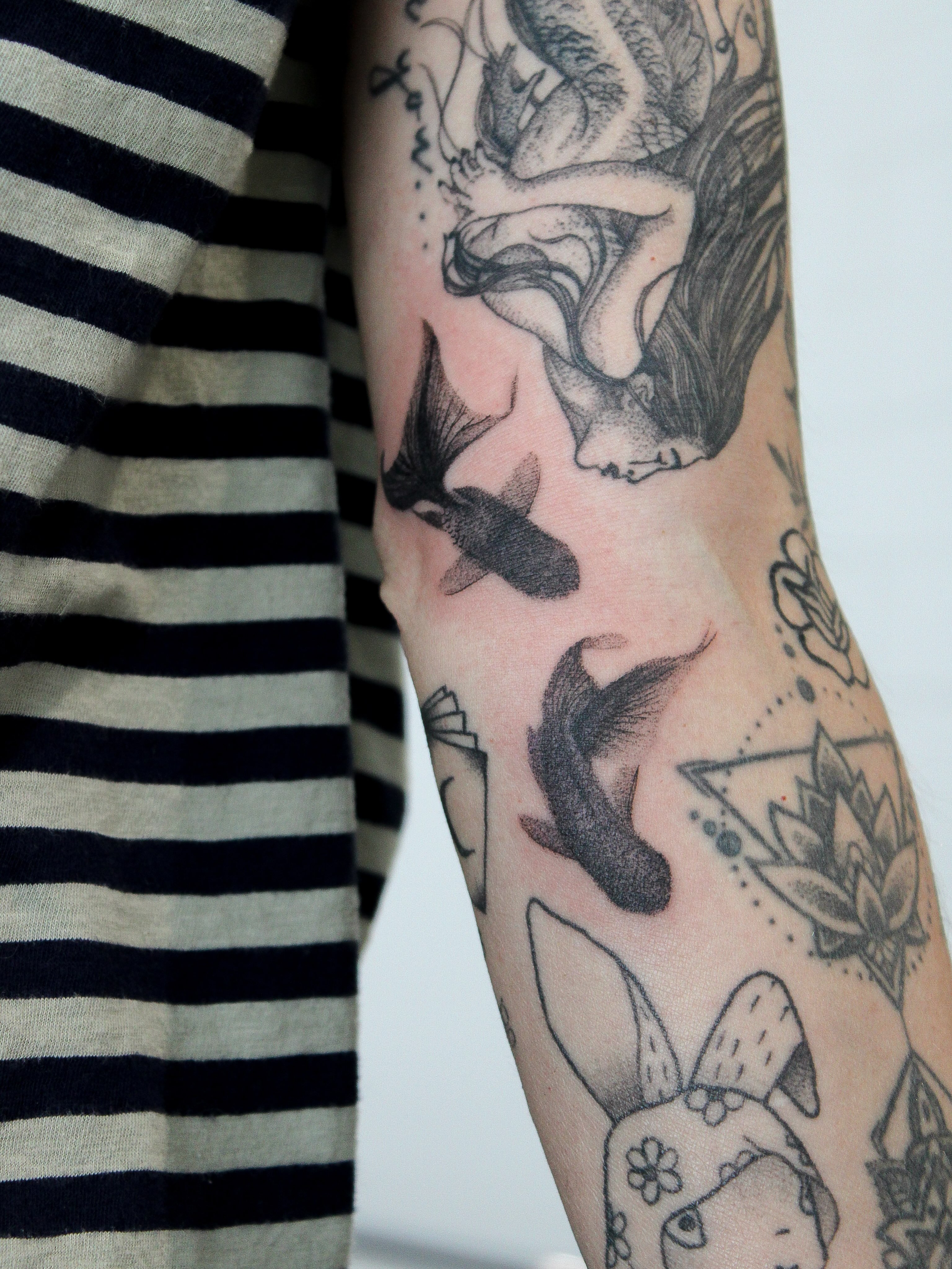Mermaid and fish black and grey tattoo on the forearm by Julianna