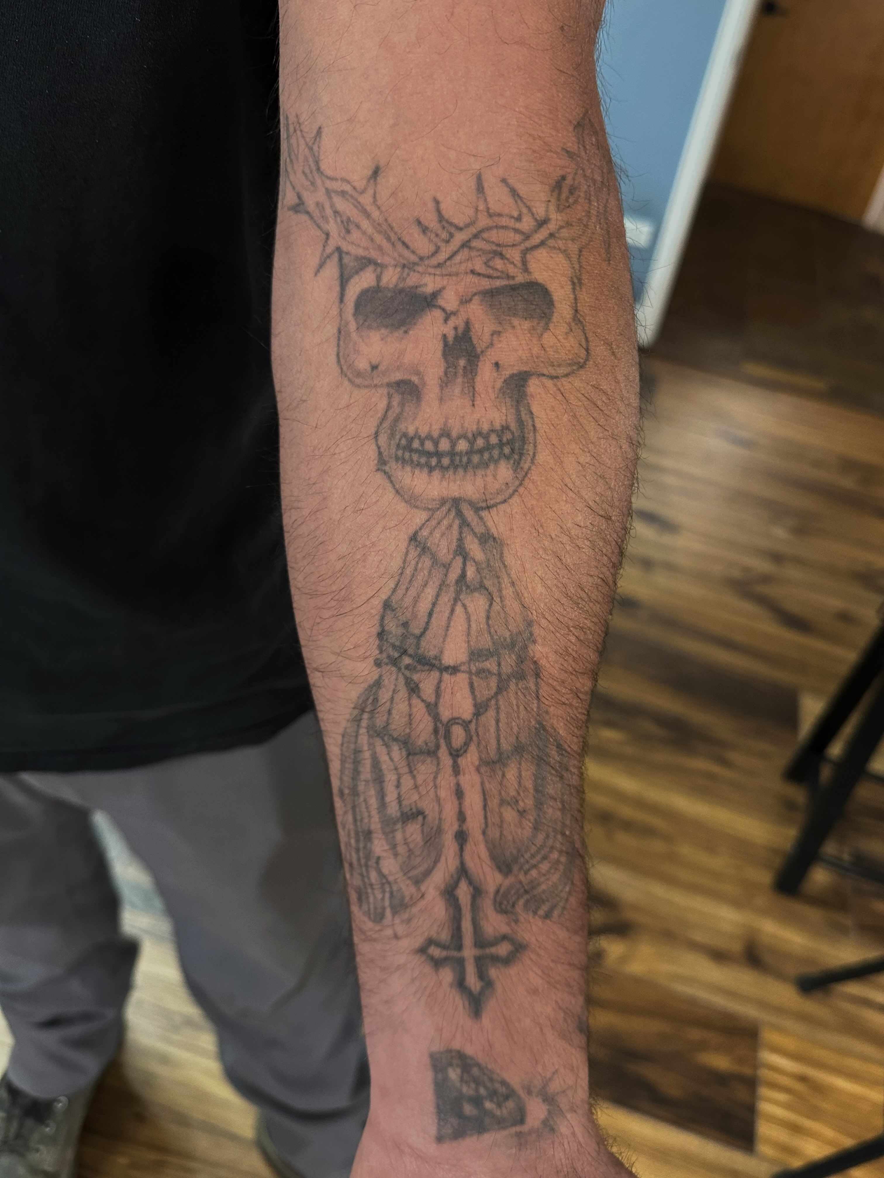 Skull with cross black and grey tattoo on the forearm by Aleksandra