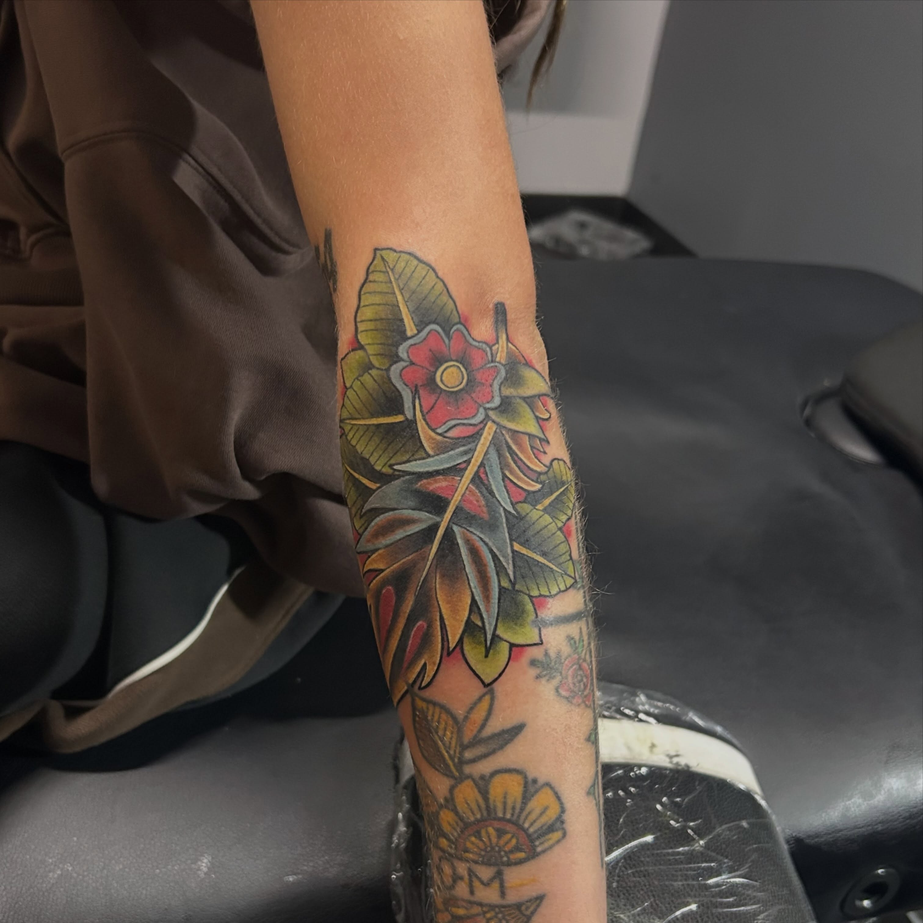 Floral arrangement American traditional tattoo on the forearm by Jamie Winn