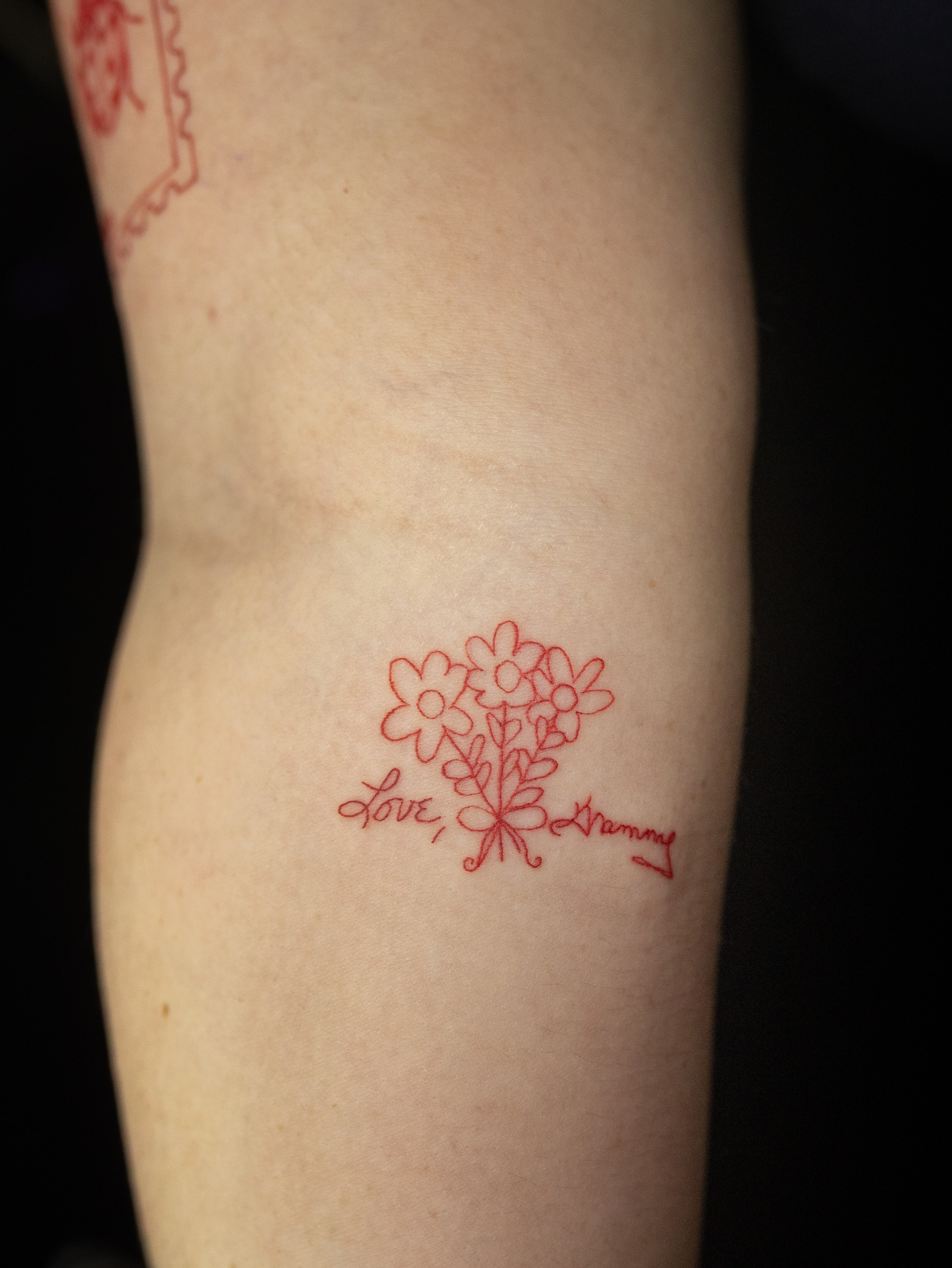Flowers and script fine line tattoo on the forearm by Kelsie