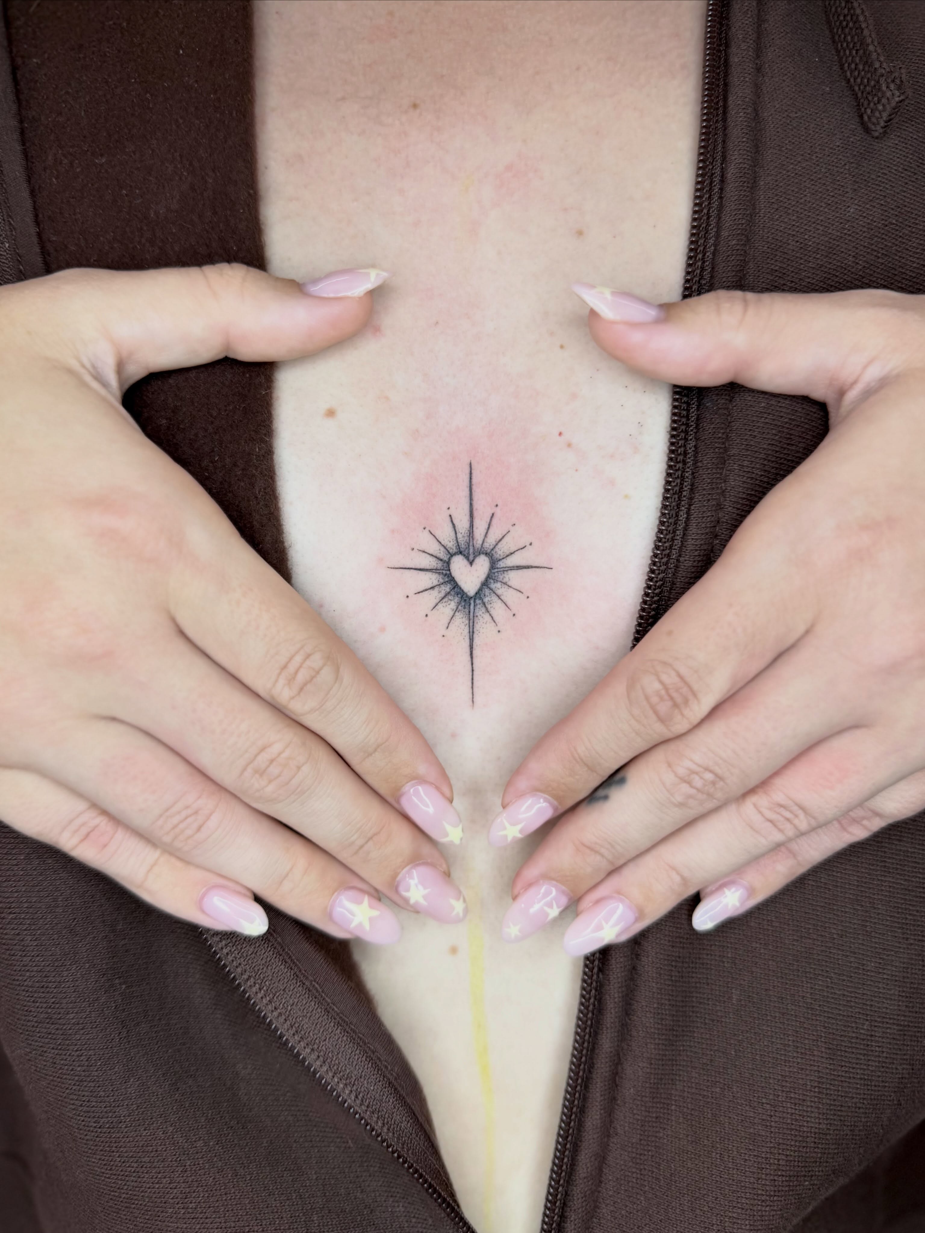 Heart with starburst geometric tattoo on the chest by Sasha “Sashimi” Shabasov