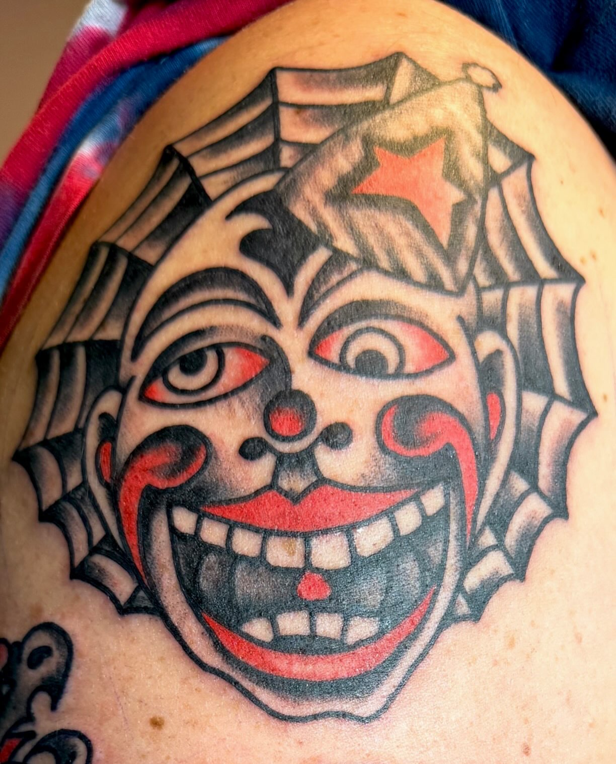 Clown face American traditional tattoo on the shoulder by David Devaney, Knoxville, Tennessee