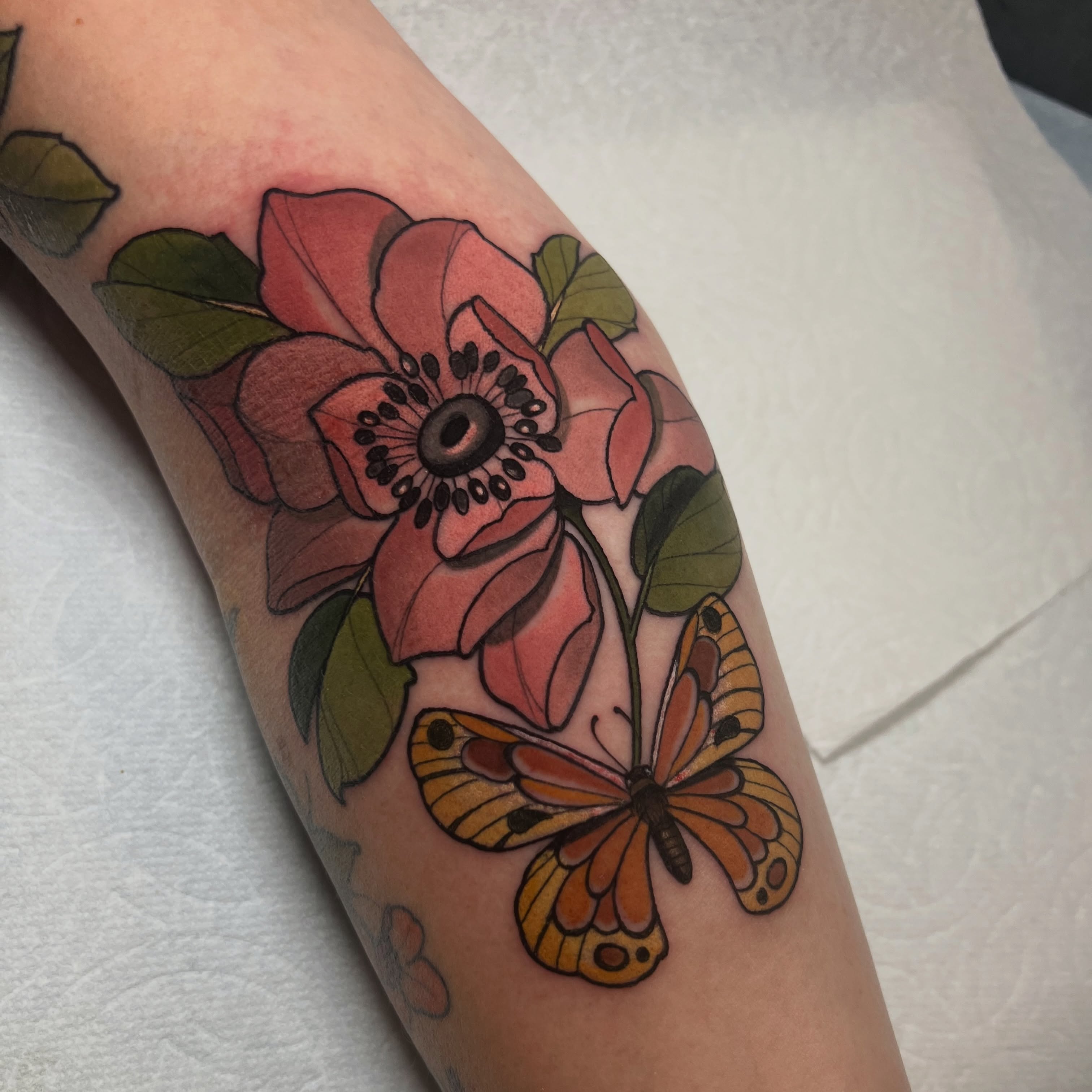 Flower and butterfly new school tattoo on the forearm by Rennie Tattoo