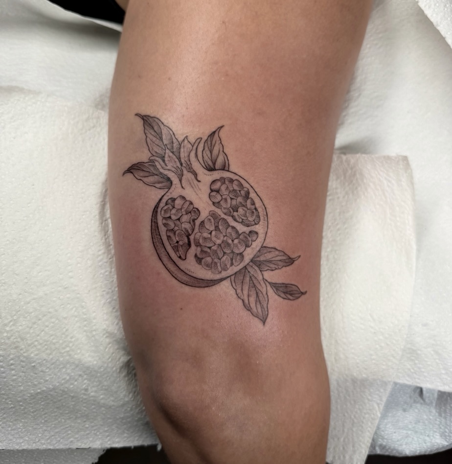 Pomegranate black and grey tattoo on the forearm by Fineline tattoos by Kinsey