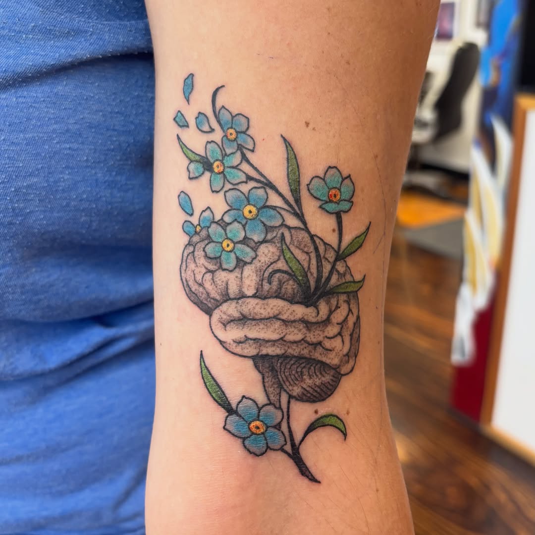 Brain and forget-me-not flowers dotwork tattoo on the forearm by Sam Hearnen, Lawrence, Kansas