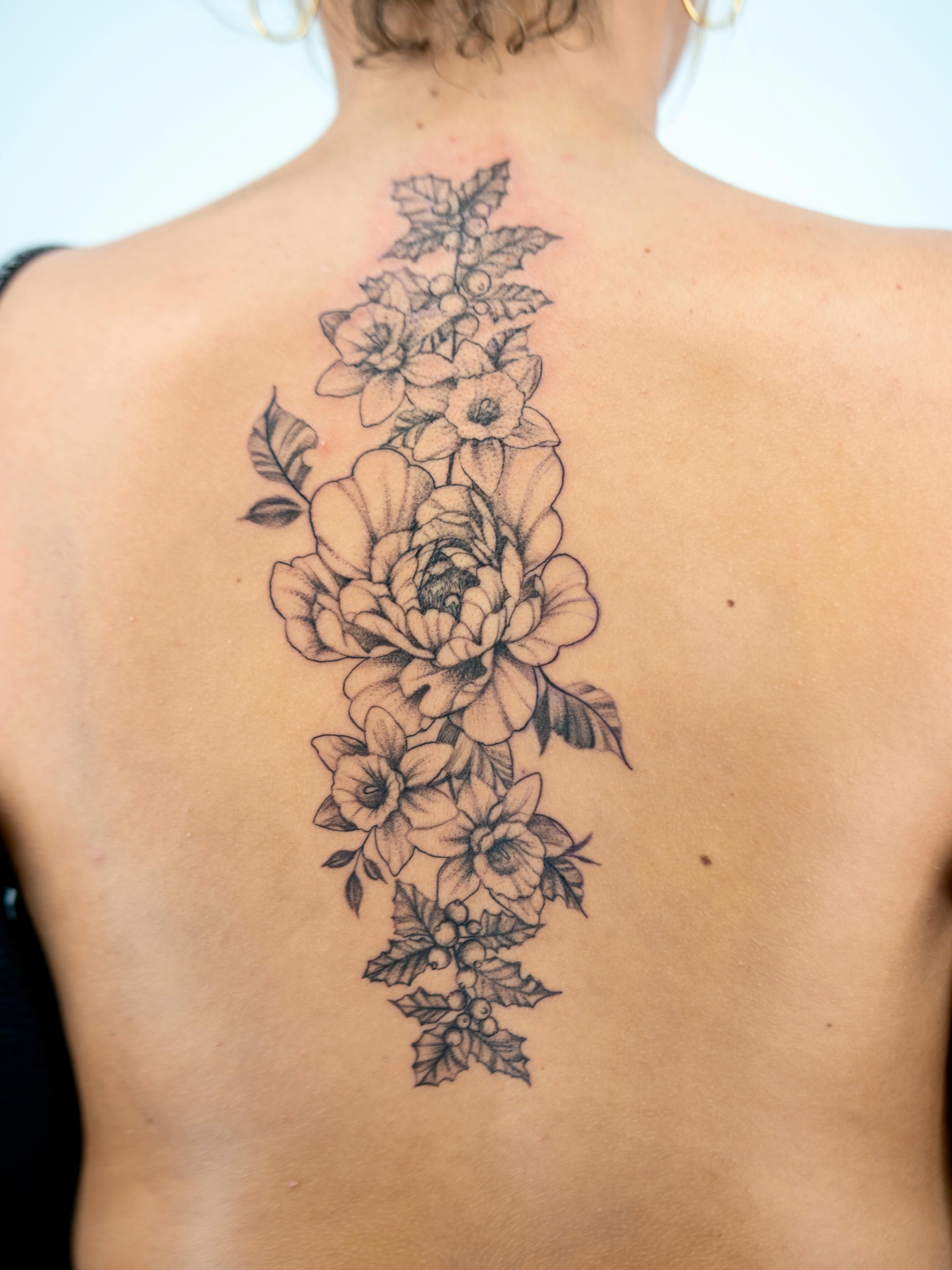 Floral arrangement black and grey tattoo on the back by Skylar