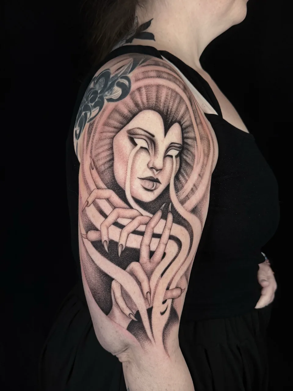Woman's face realism tattoo on the upper arm by Tattoo Artist