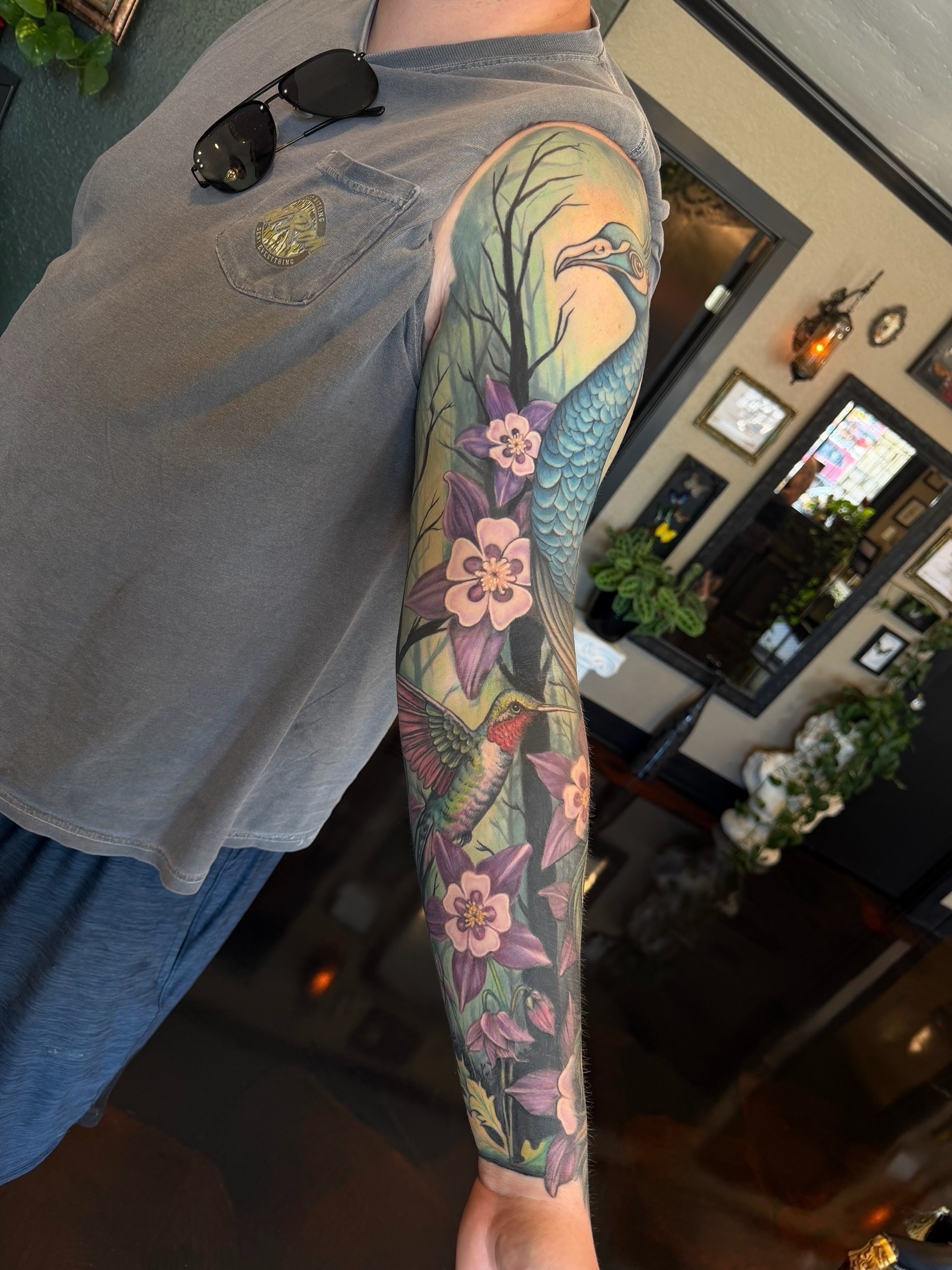 Hummingbird and flowers realism tattoo on the forearm by Shae Sullivan