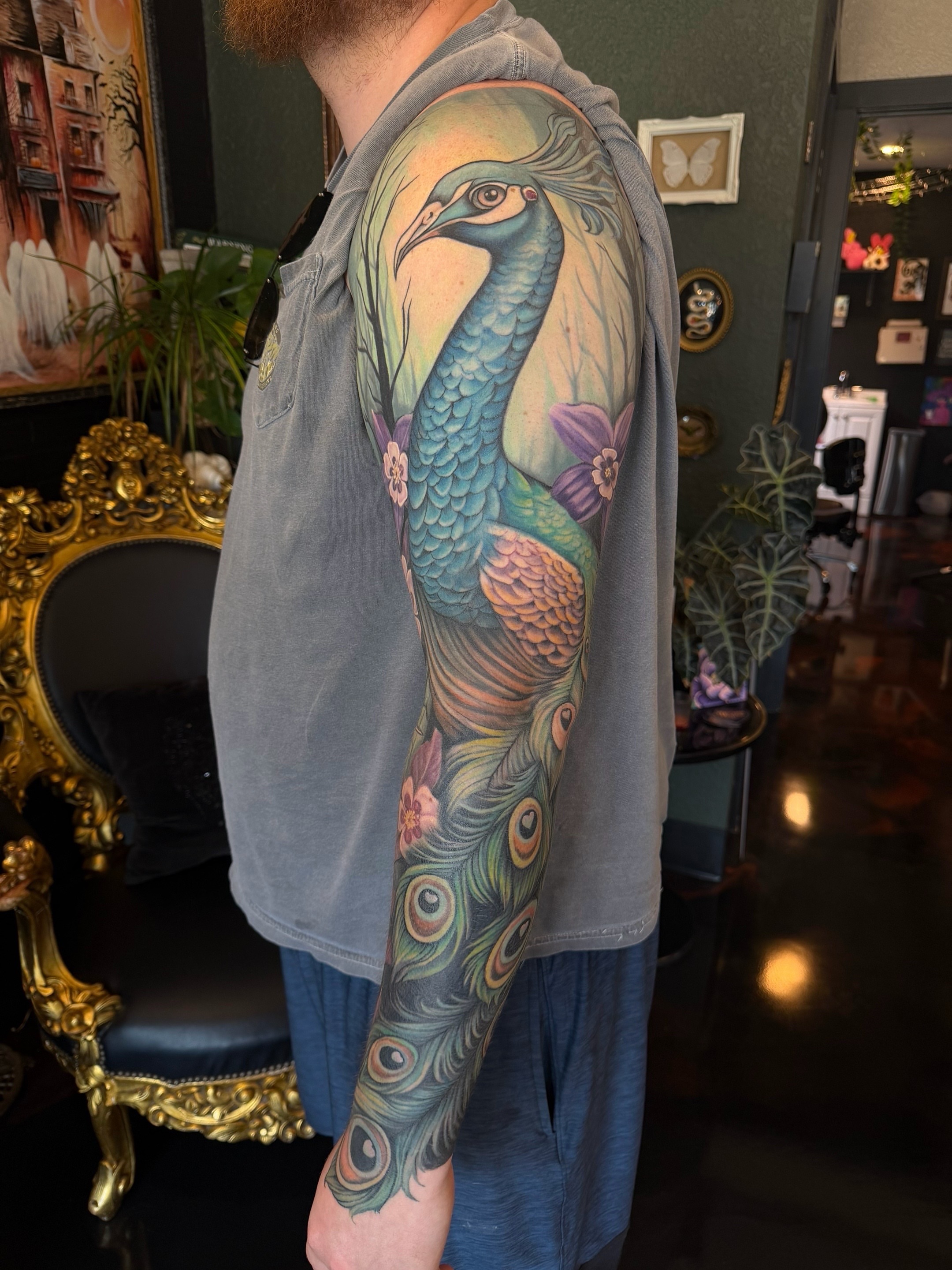 Peacock realism tattoo on the upper arm by Shae Sullivan