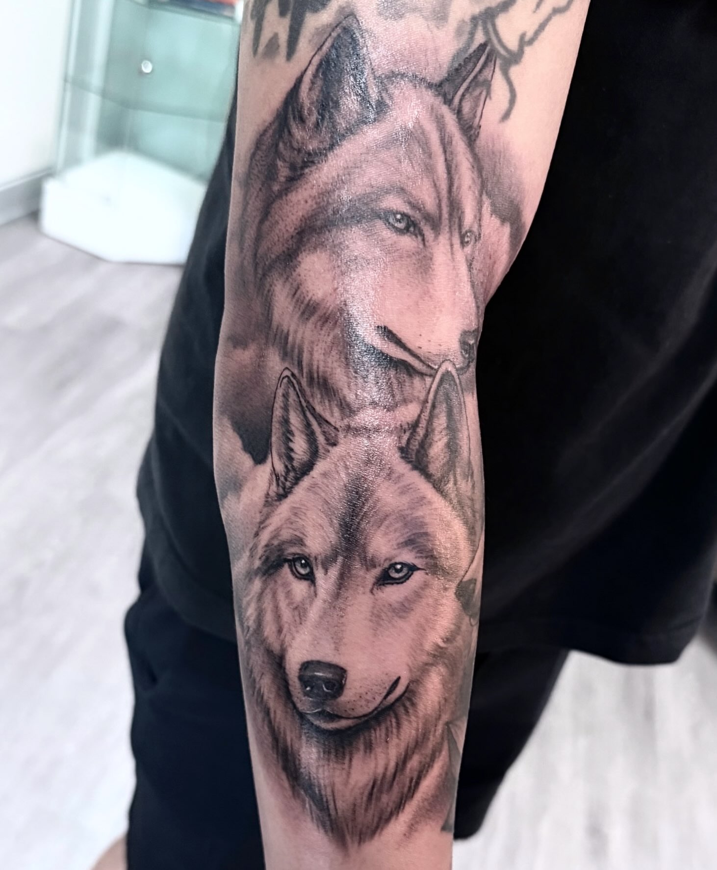Wolves realism tattoo on the forearm by Eric Axle