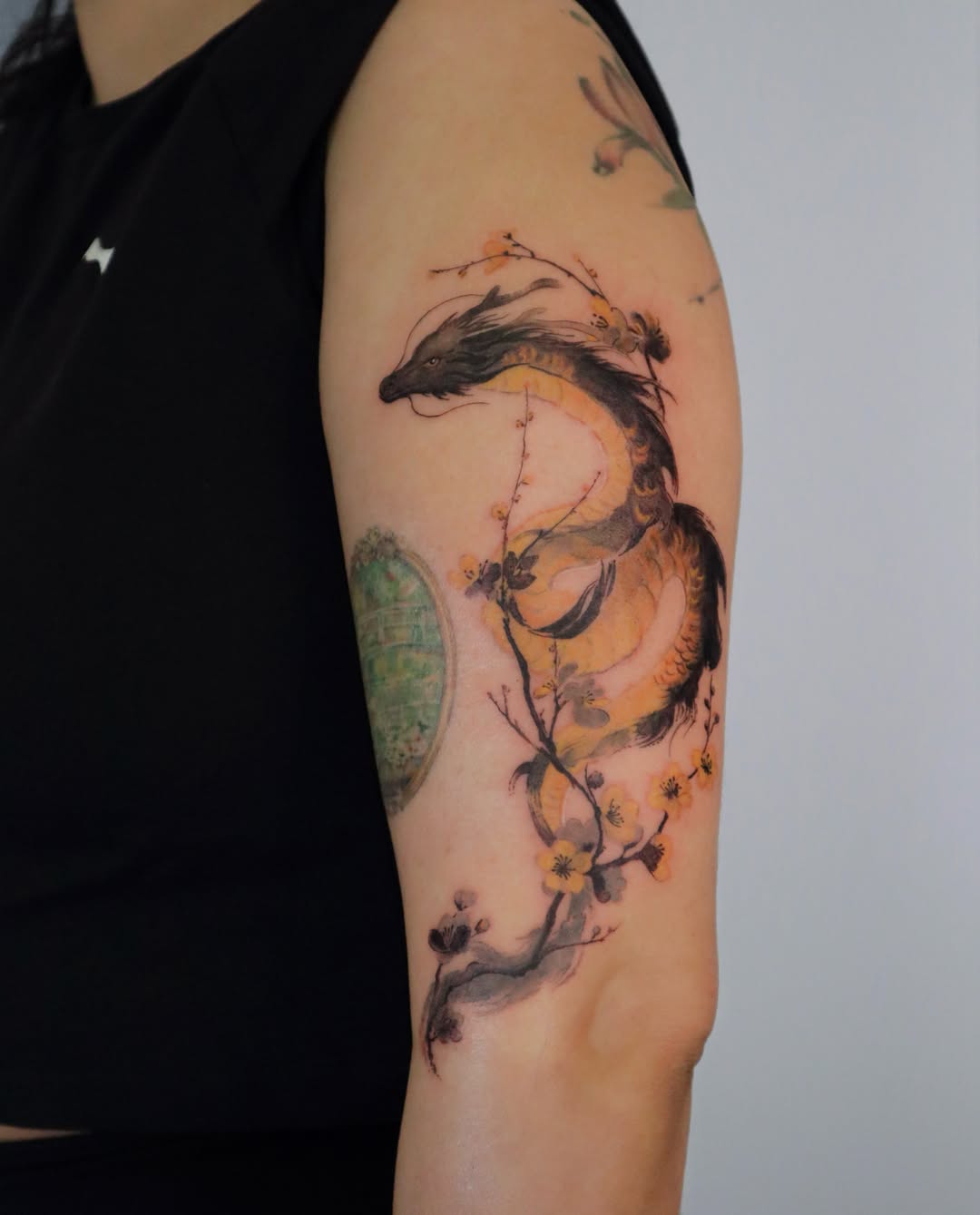 Dragon and blossoms watercolor tattoo on the forearm by Sylvia｜思岐, Vancouver, British Columbia