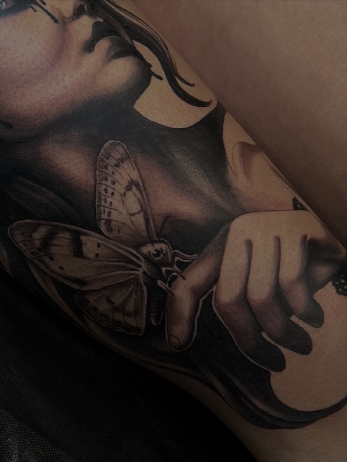 Woman with butterfly realism tattoo on the upper arm by Tattoo Artist Mimzi PMA