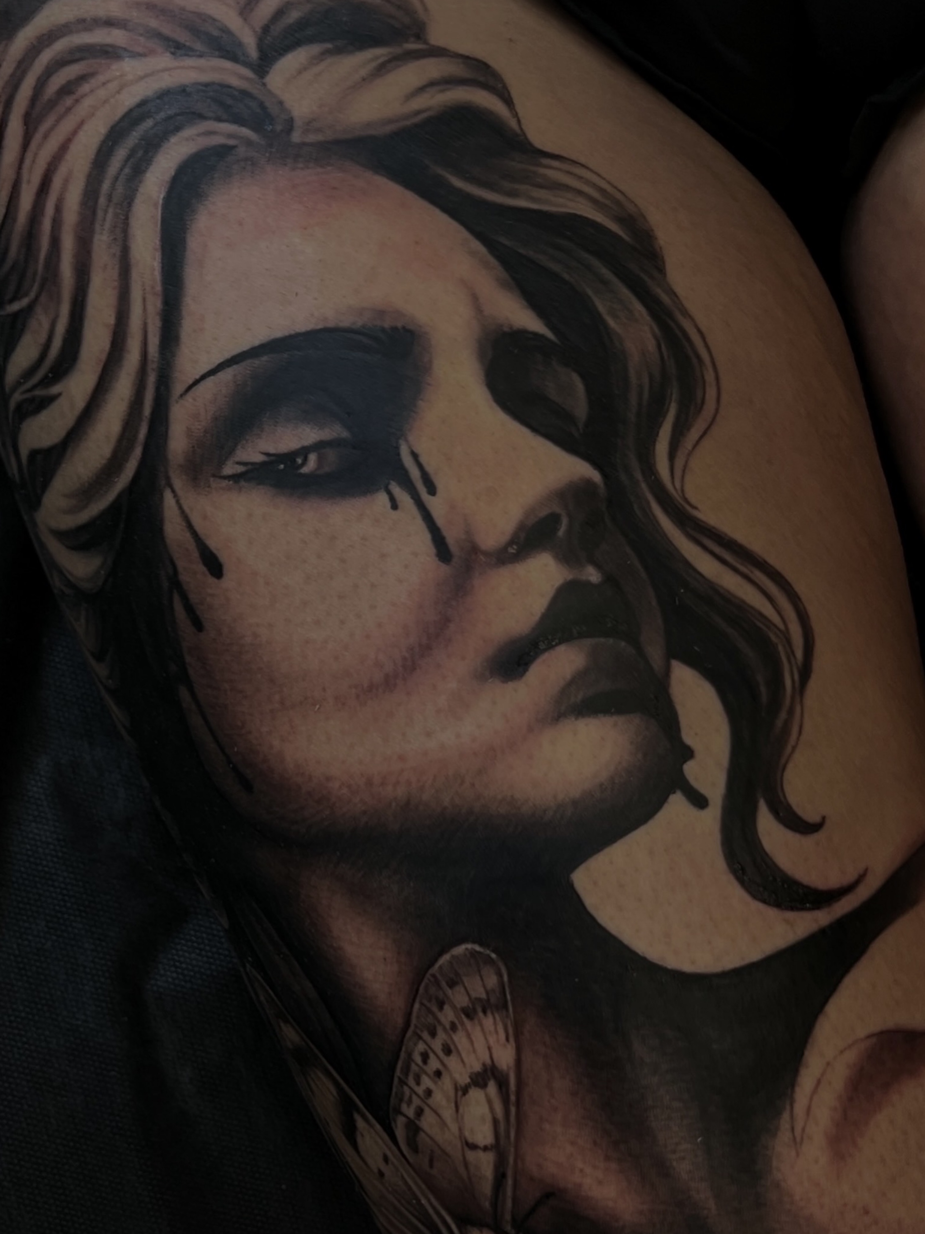 Woman's face realism tattoo on the thigh by Tattoo Artist Mimzi PMA