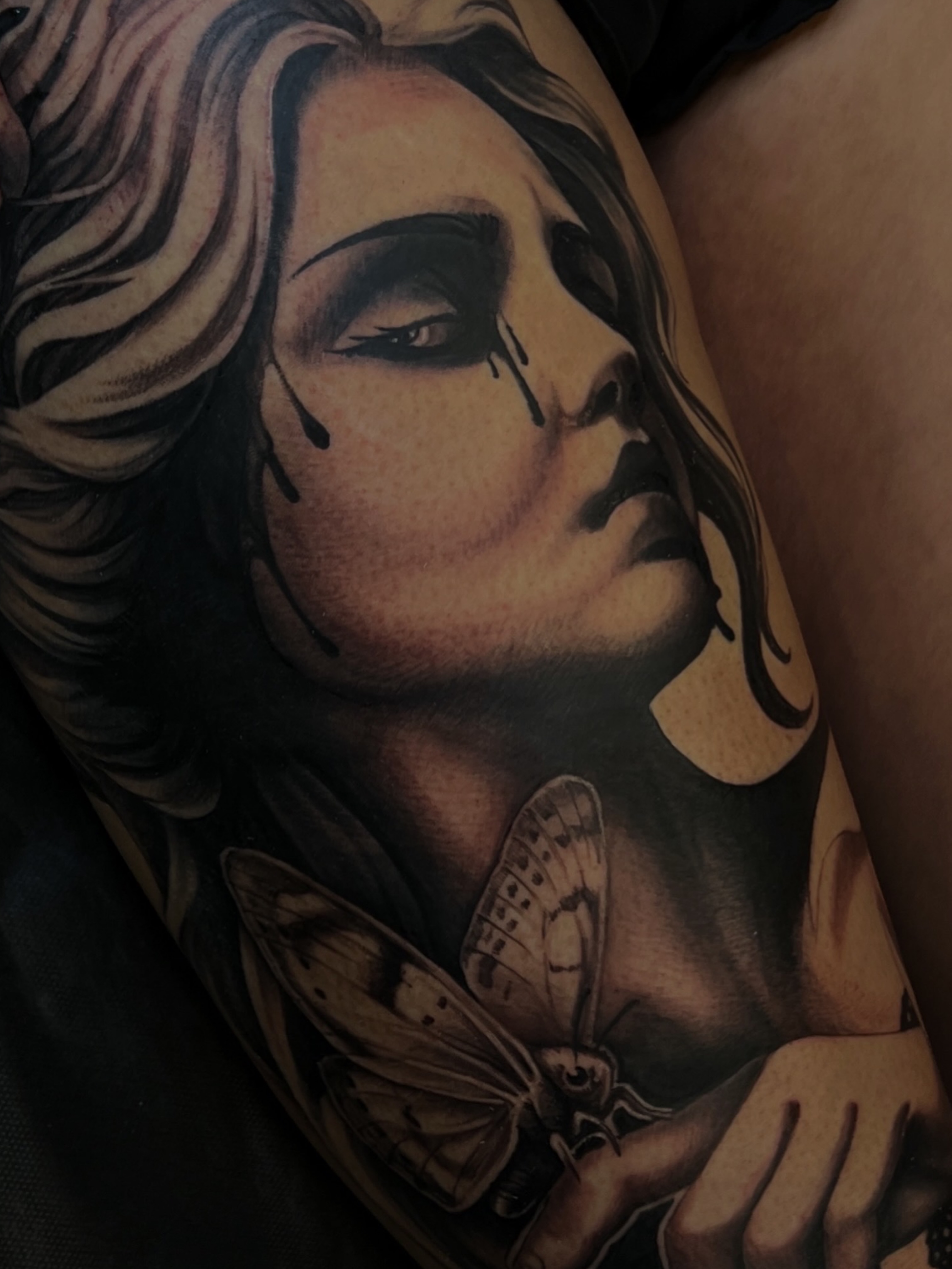Woman with butterfly realism tattoo on the upper arm by Tattoo Artist Mimzi PMA