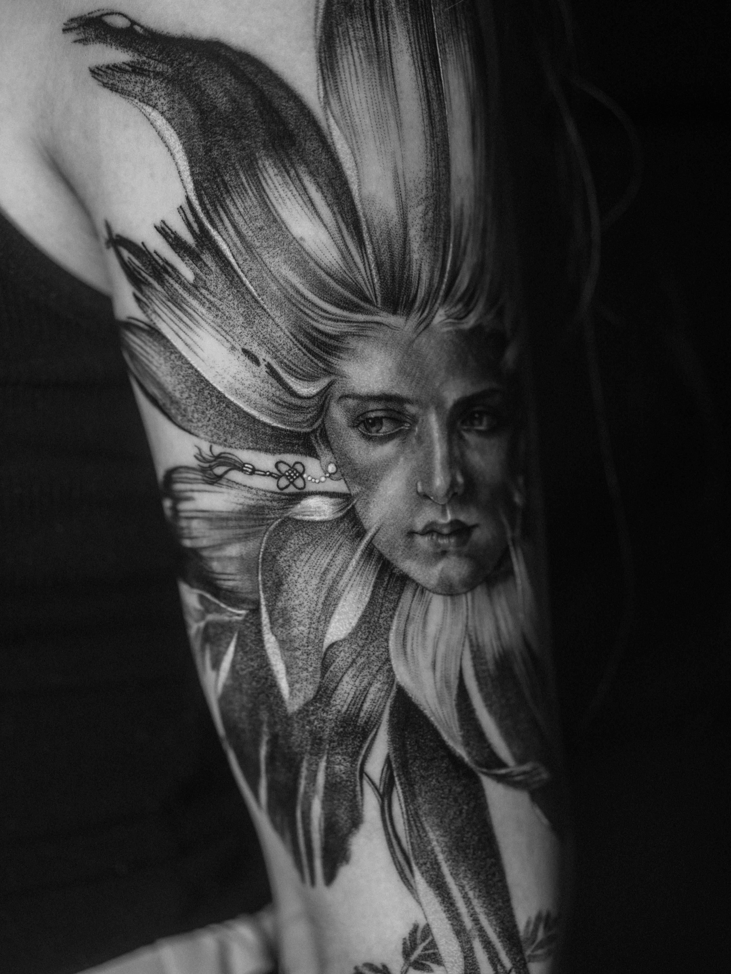 Woman's face realism tattoo on the upper arm by Lejo bravo