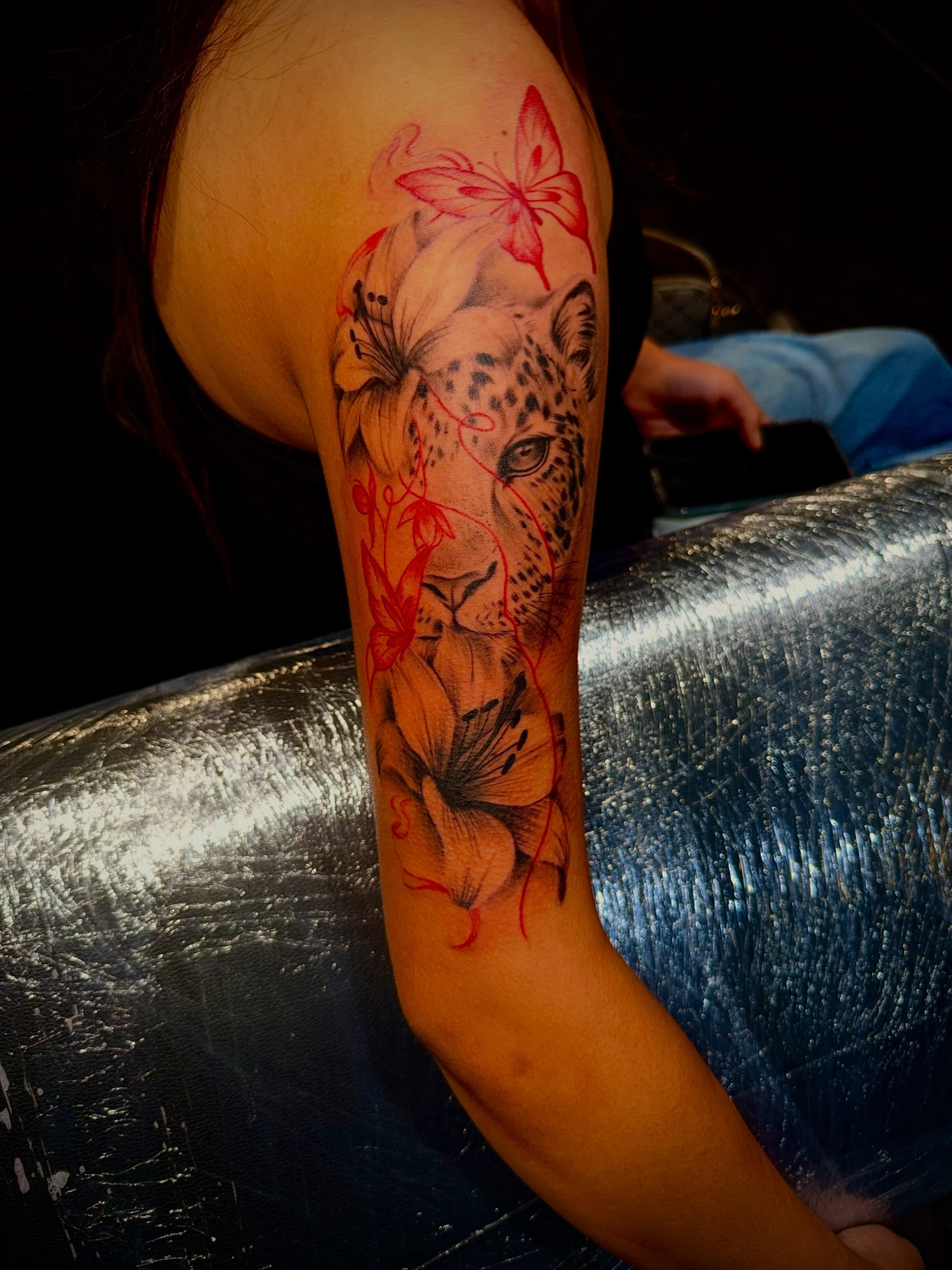 Leopard and flowers realism tattoo on the forearm by Clifford Jordan