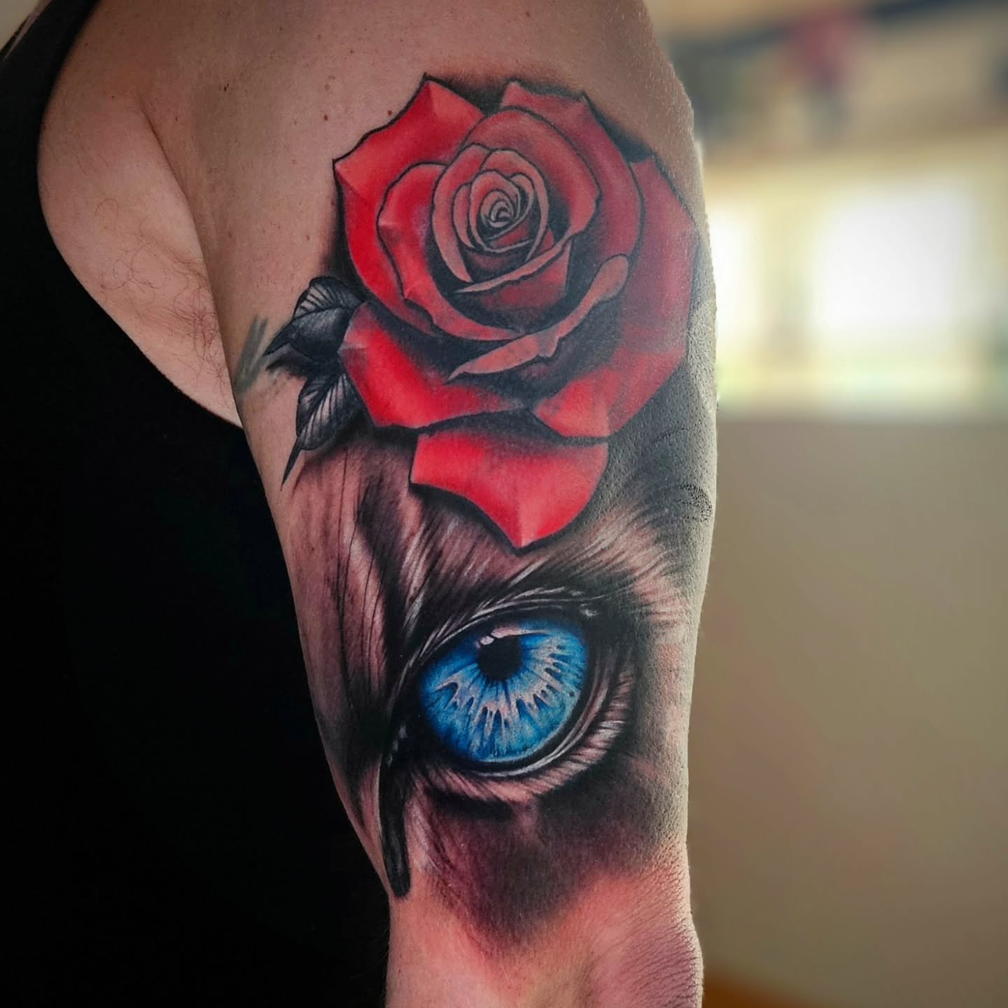 Red rose with blue eye realism tattoo on the forearm by Justin J-rust Smith